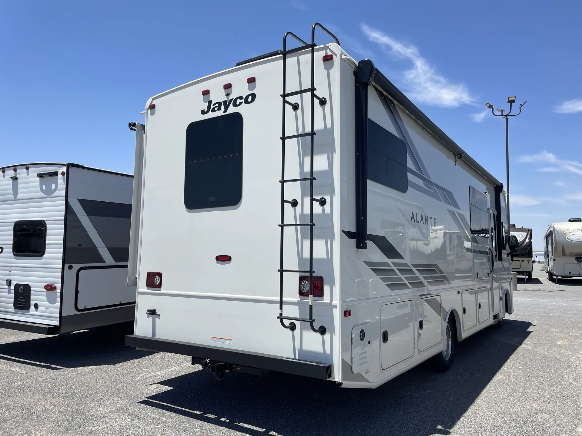 2027 Jayco Alante 29F — Rear-side exterior photograph visibly shows the motorhome rear, ladder, side graphics, slide-out, and lower storage compartments