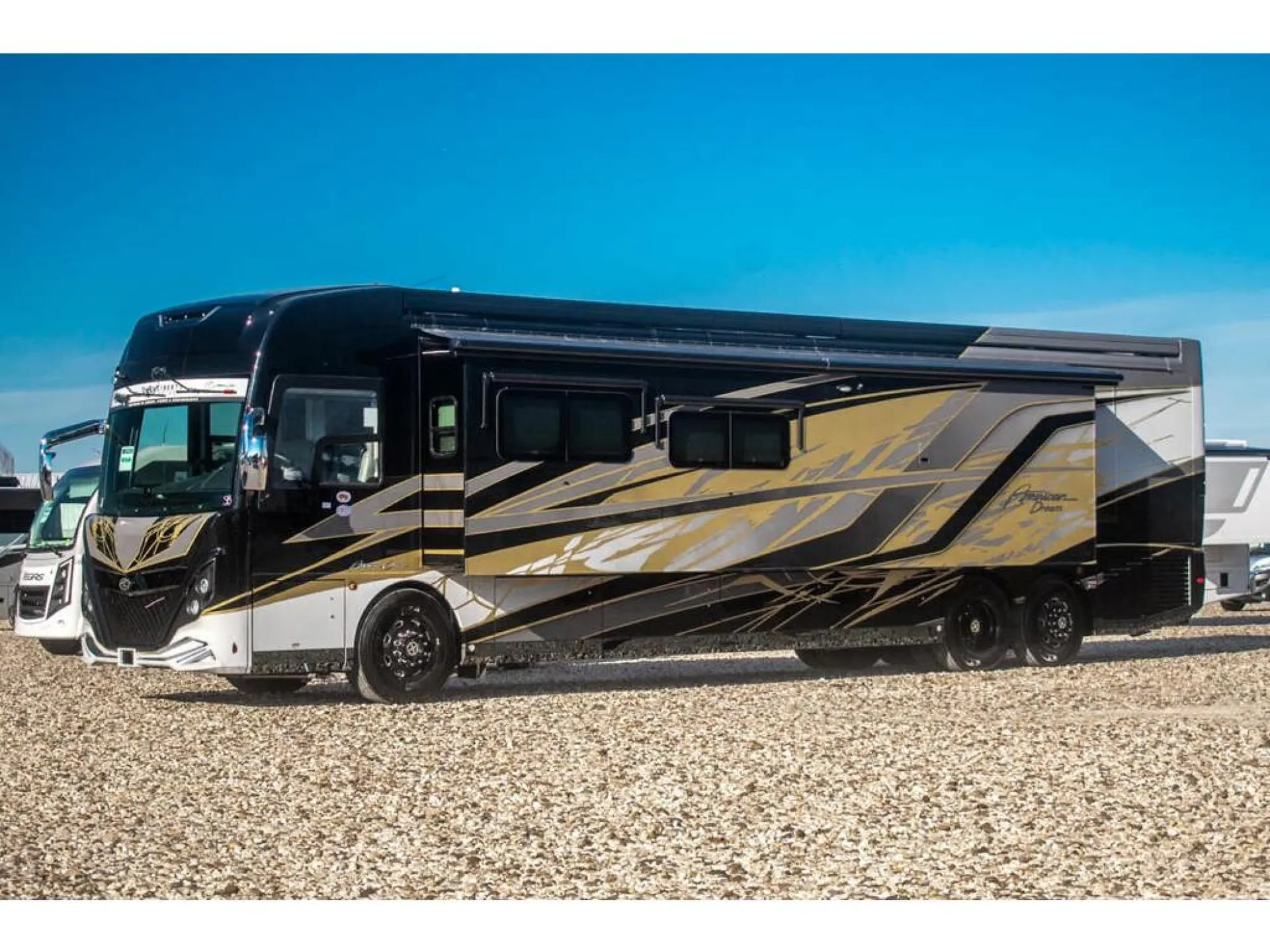 2026 American Coach American Dream 45A — Full side view visibly shows the motorhome exterior, including body shell, windows, wheels, and awning