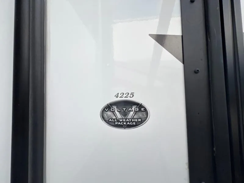 2023 Dutchmen Voltage 4225 — Close-up photograph shows the exterior-mounted '4225 Voltage All Weather Package' badge on the RV