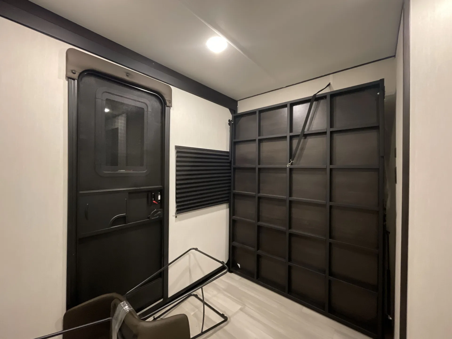 2026 Forest River Cherokee Wolf Pack 397STAY — Toy-hauler garage contains a rear entry door, large folding ramp-wall structure, window, and loose folded furniture