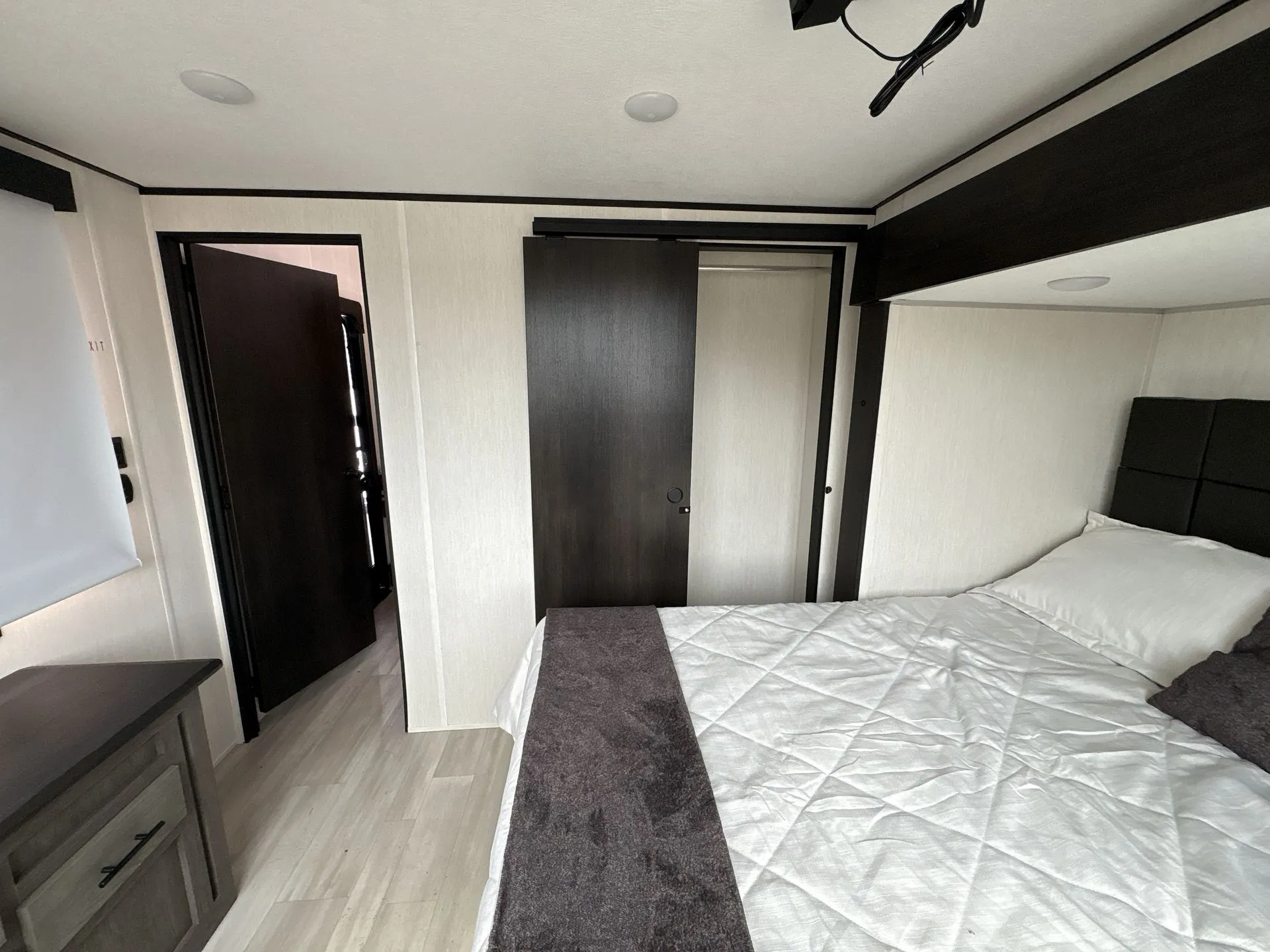 2026 Forest River Cherokee Wolf Pack 397STAY — Main bedroom with bed, sliding wardrobe door, dresser, window shade, and entry doorway