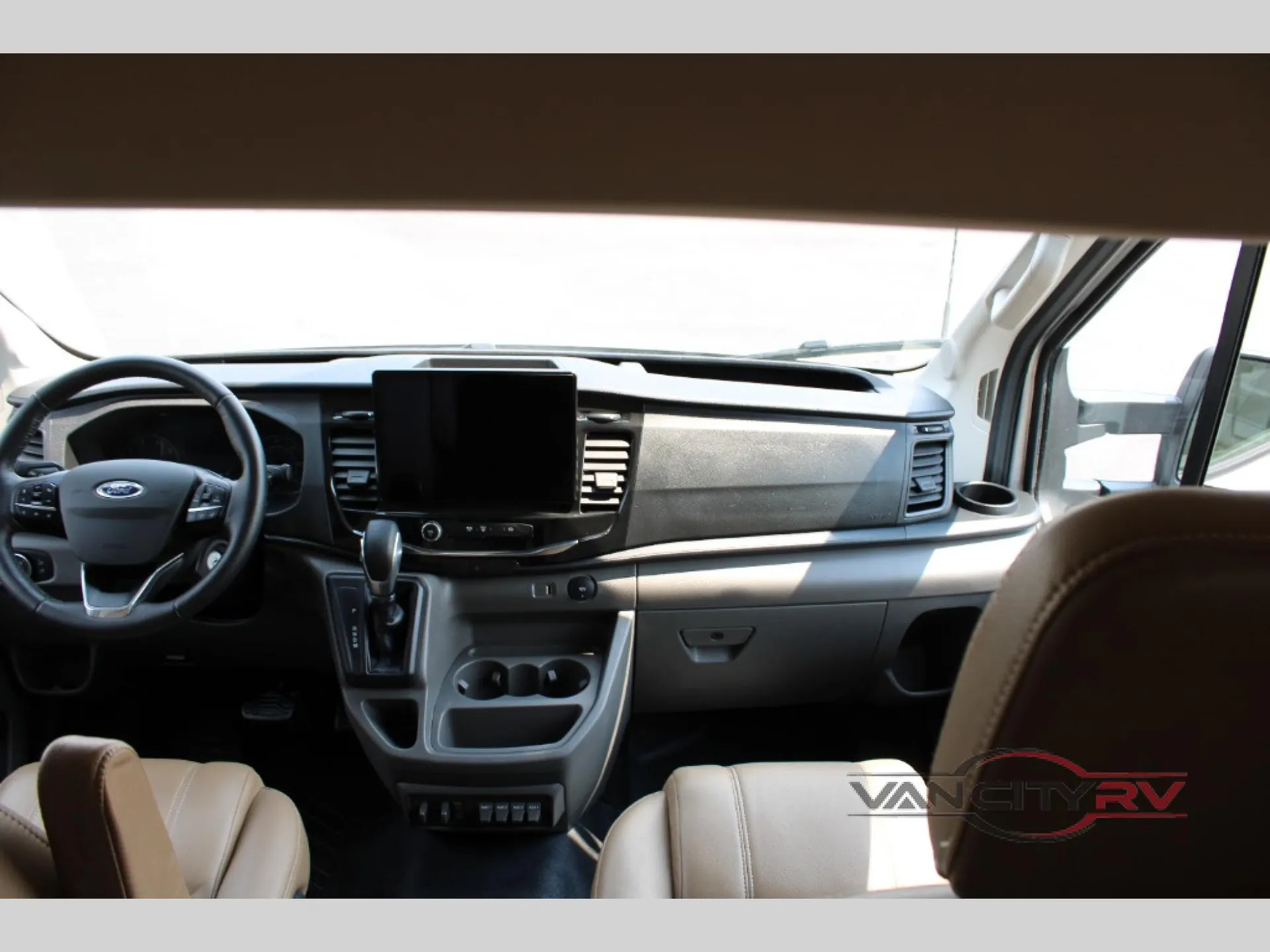 2025 Chinook RV Maverick SS — Class B van cockpit with steering wheel, dashboard touchscreen, gear selector, climate controls, cupholders, and front seats