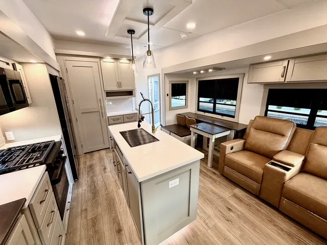 2026 Brinkley Model Z 3610 — Dinette beside large windows faces a kitchen island, with leather recliners occupying the adjacent lounge area