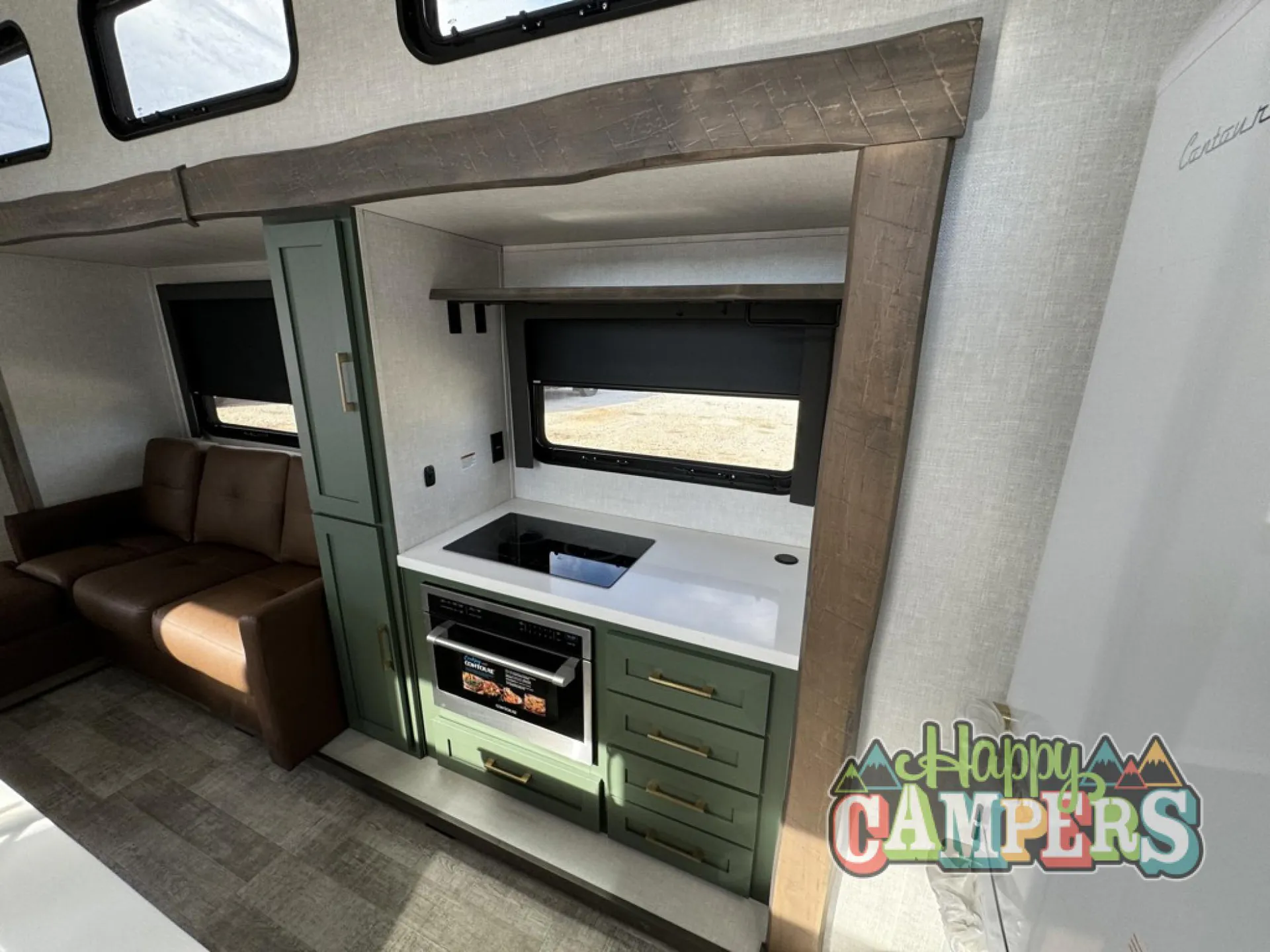 2025 Forest River IBEX RVS3 — Kitchen counter with sink, oven, drawers, and overhead shelf beside a visible living-room sofa