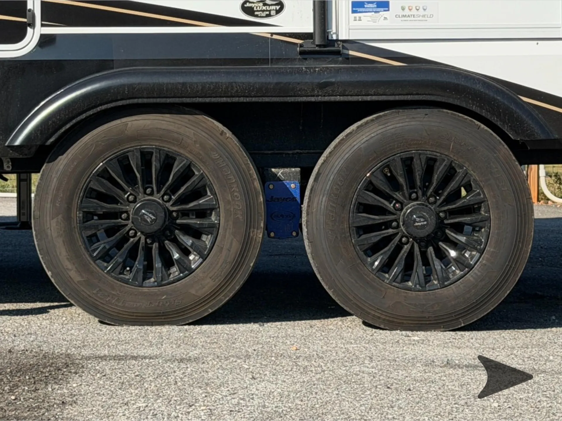 2027 Jayco Pinnacle 39FLOK — Close exterior photograph primarily shows the RV's tandem wheels and wheel-well assembly