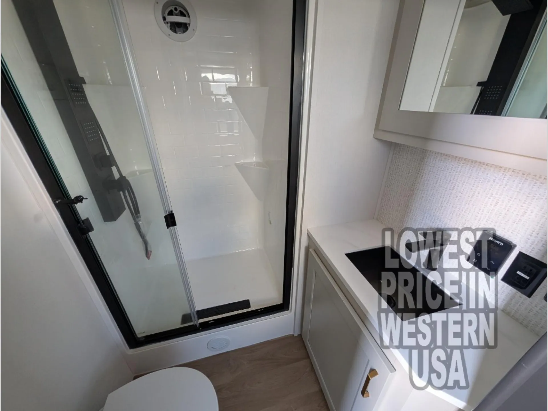 2026 Grand Design Foundation 42GD — Compact bathroom with glass shower, toilet, vanity sink, mirror, and wall controls