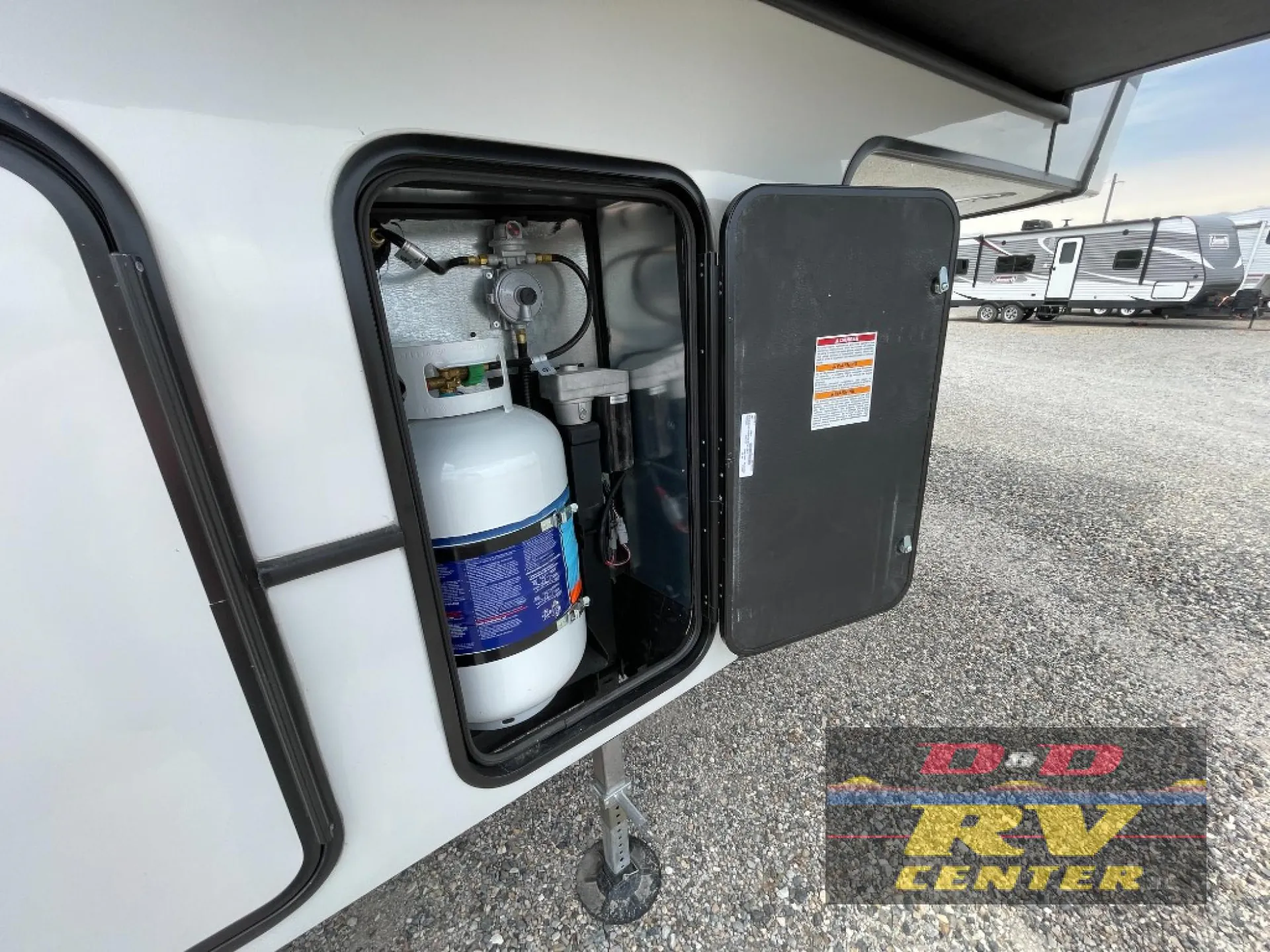2026 Keystone Montana High Country 377FL — Open exterior compartment visibly contains a propane cylinder and associated gas regulator/plumbing equipment