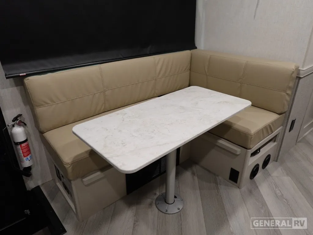 2026 Holiday Rambler Invicta 36Y — U-shaped dinette booth with a freestanding table, storage drawers, and overhead window shade