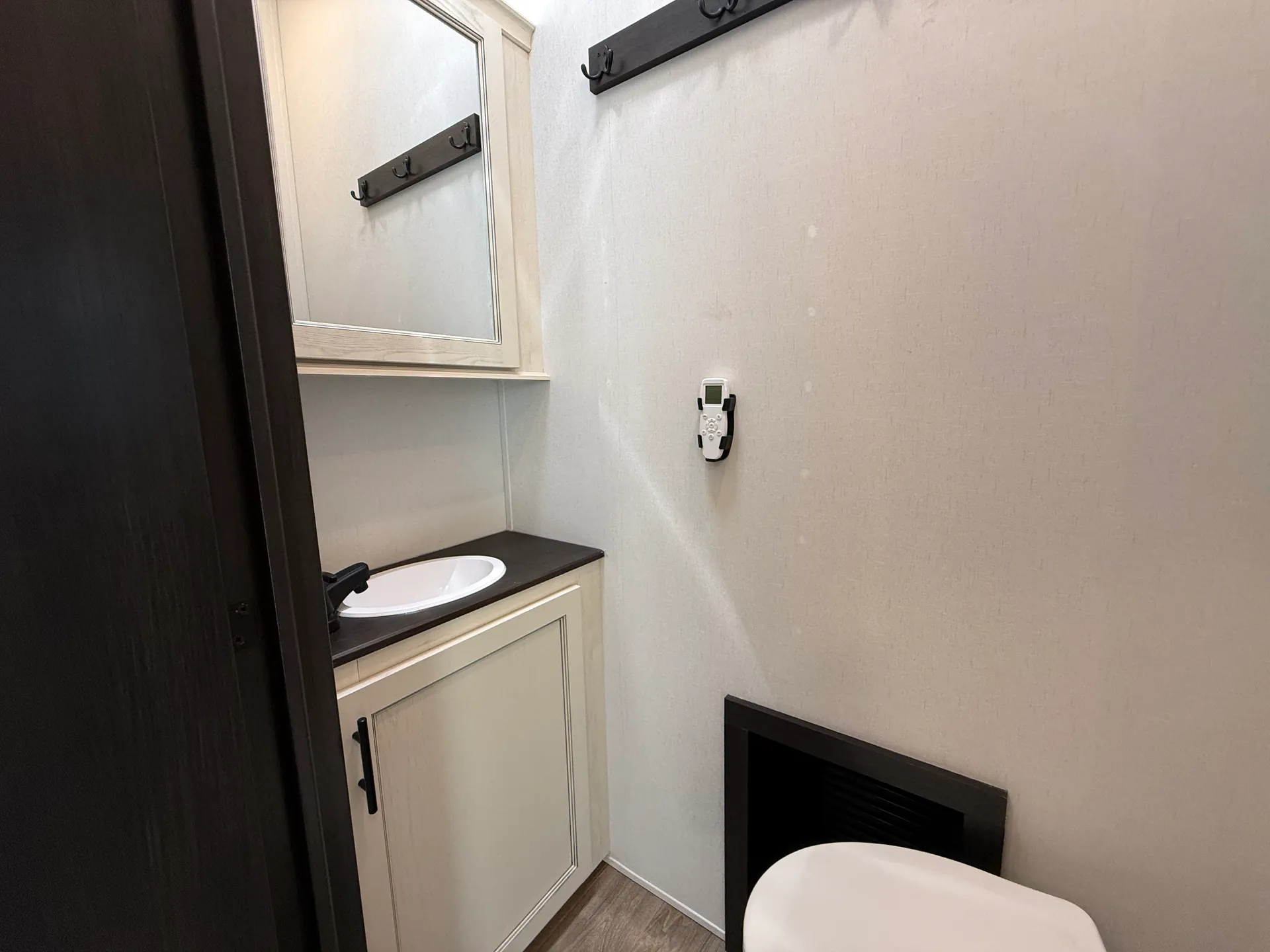 2027 Forest River Sabre 38RVHUNTER — Fifth wheel bathroom vanity with oval sink, mirrored medicine cabinet, hooks, thermostat, and toilet edge