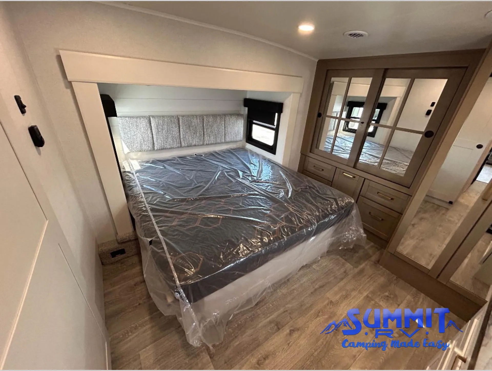 2027 Jayco Eagle 355MBQS — Main bedroom with covered bed, mirrored wardrobe, drawers, windows, and surrounding floor space