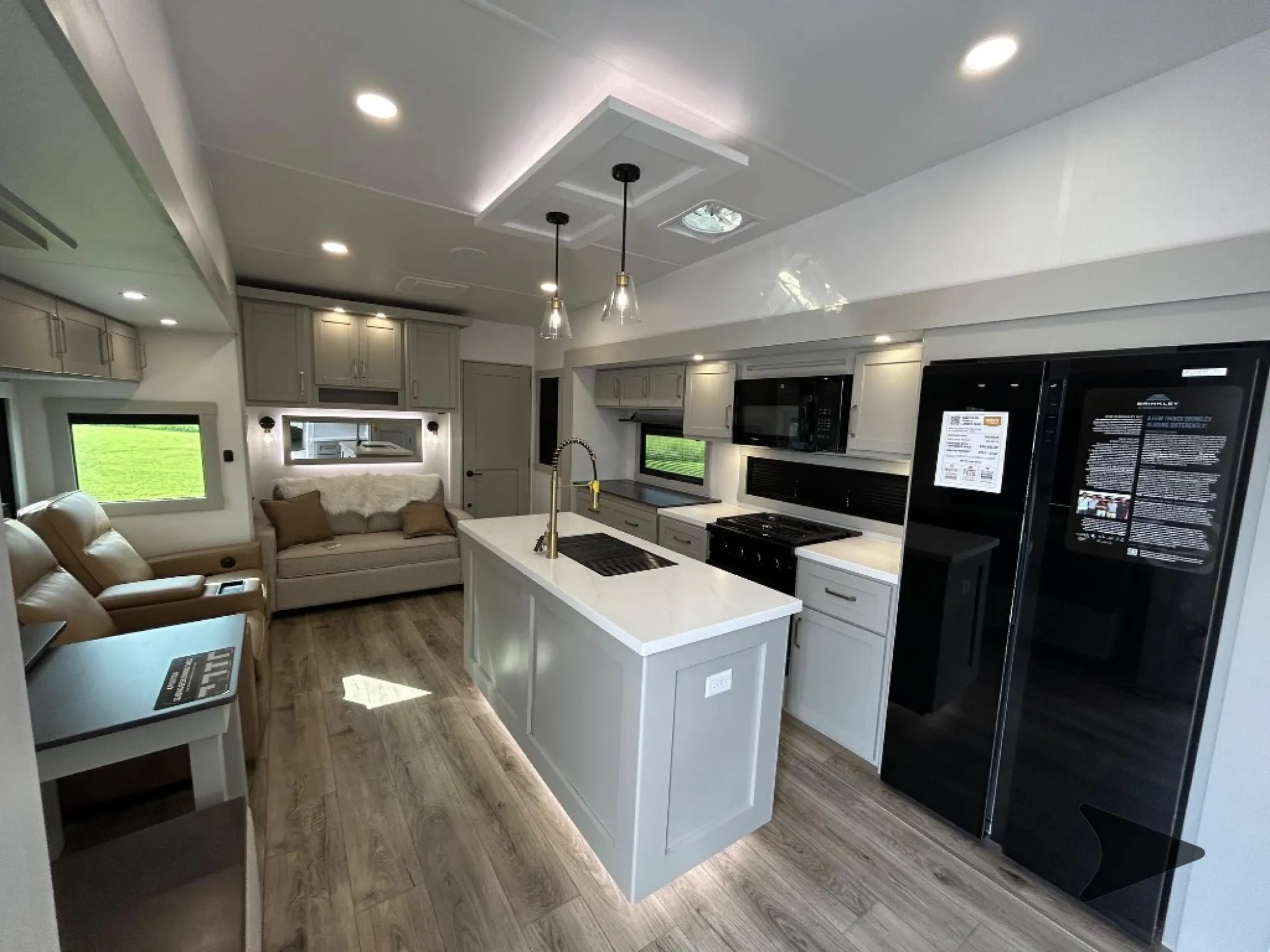 2026 Brinkley Model Z 3515 — Fifth wheel kitchen island with sink and appliances overlooking sofa, recliners, and adjacent dining table