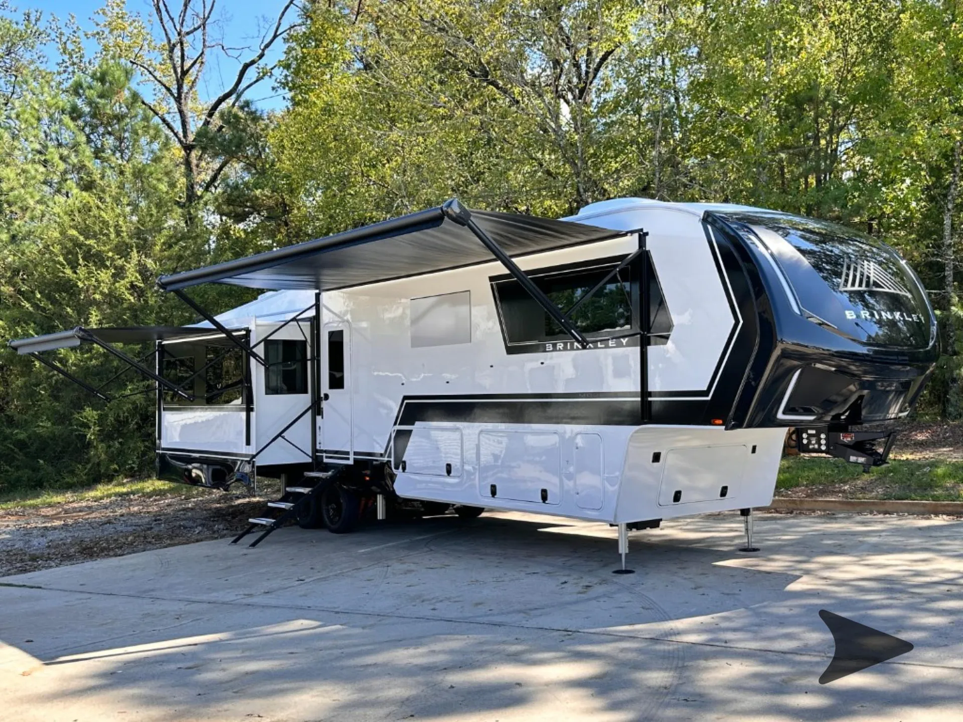 2026 Brinkley Model Z 3610 — Photo visibly shows the RV exterior with deployed awnings, slide-outs, entry steps, wheels, and landing supports