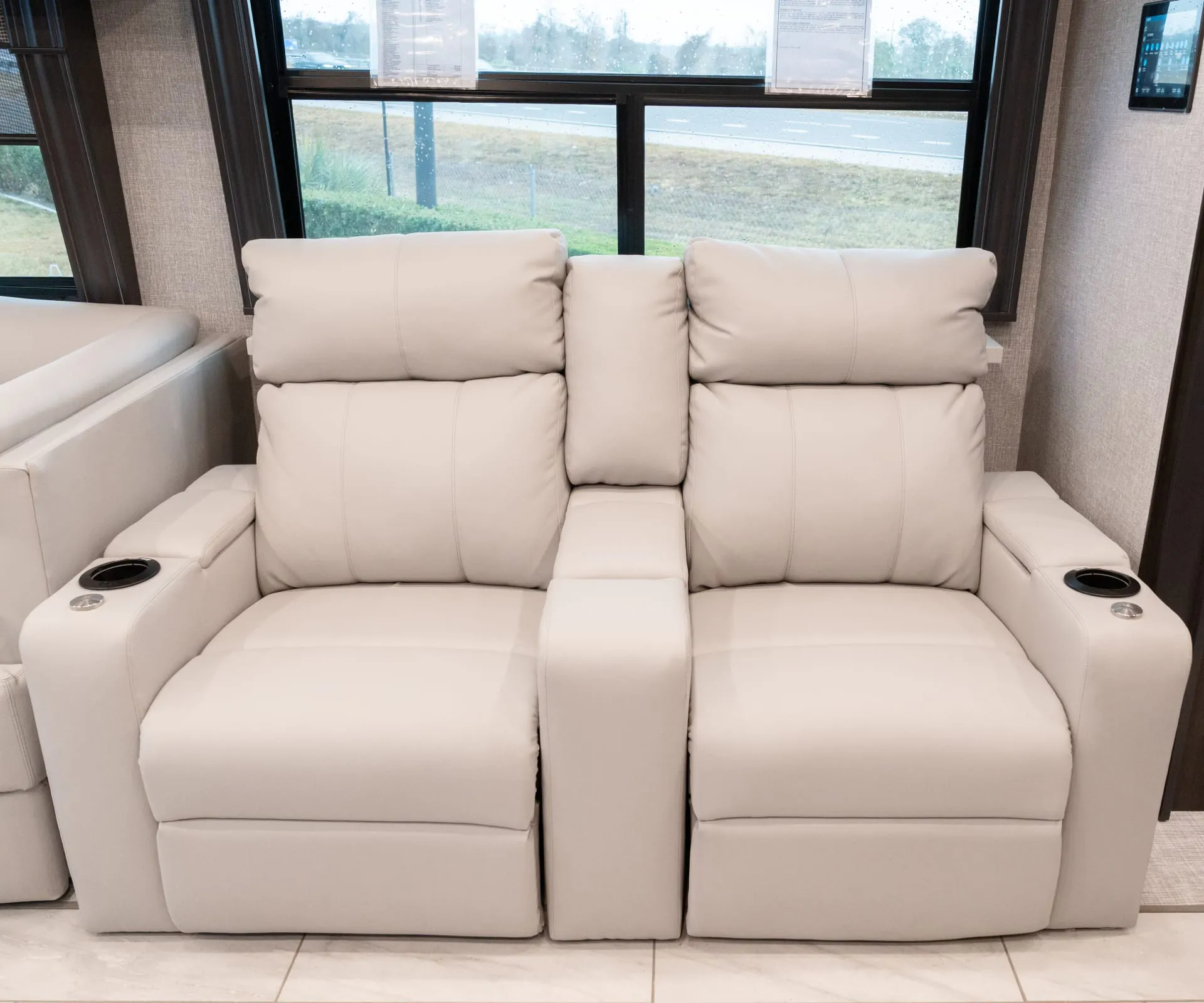 2026 Fleetwood Discovery LXE 40G — Pair of recliners with center console and cup holders beneath a large RV window