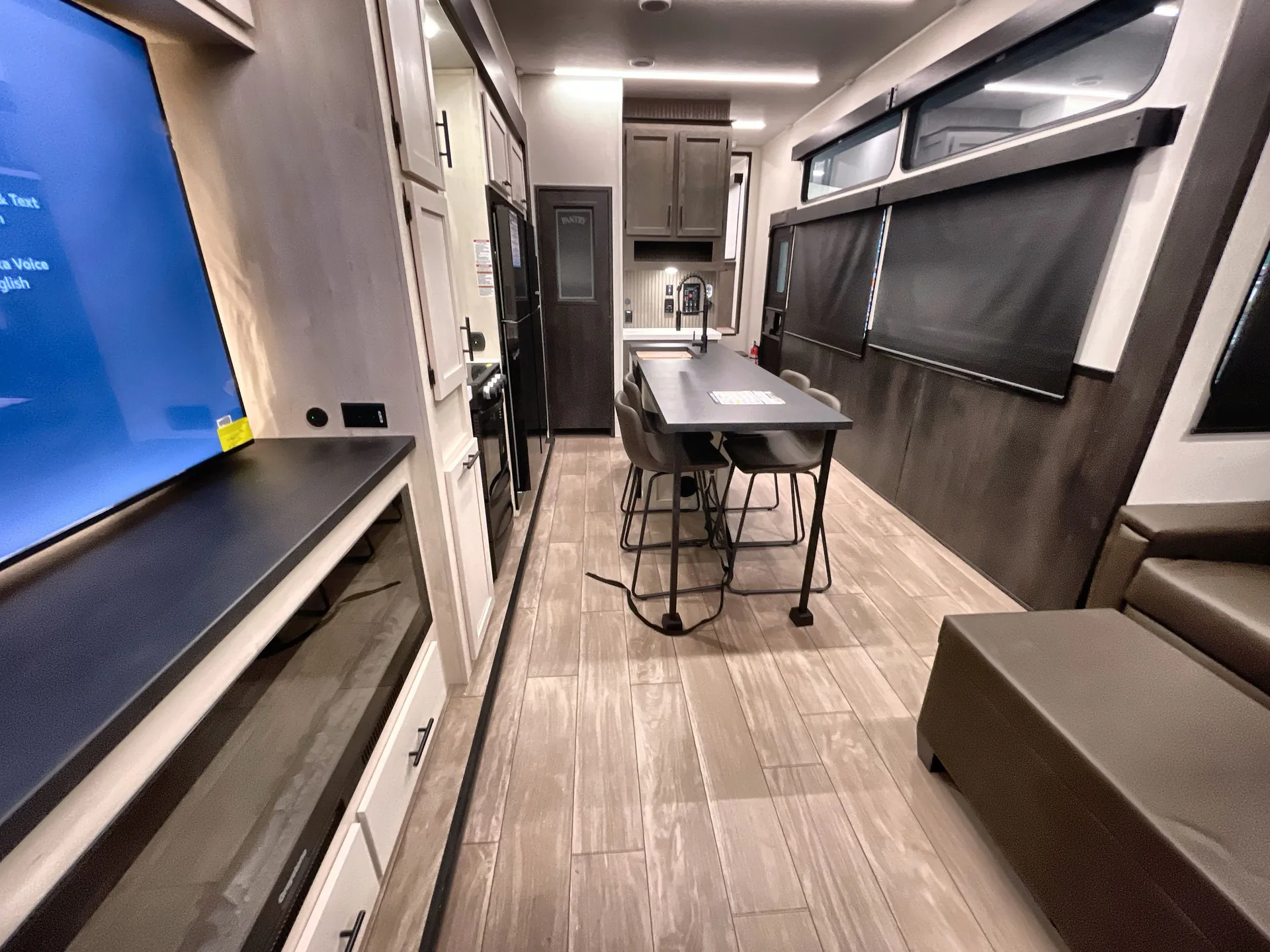 2026 Forest River Arctic Wolf 38LEAH.G — Fifth wheel interior overview with dining table, kitchen appliances and cabinetry, entertainment center, and sofa