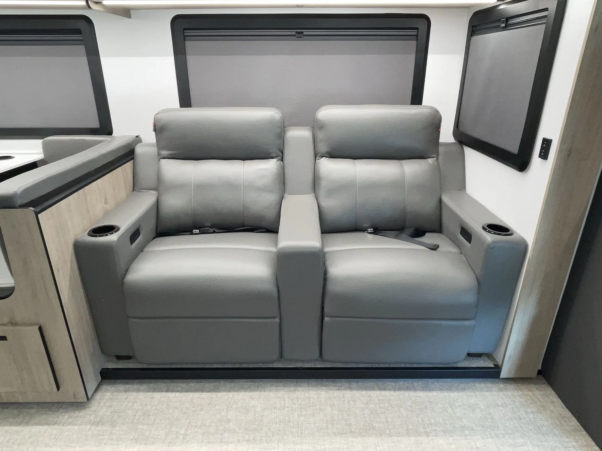 2027 Grand Design Lineage Series F 31ZW — Two gray theater recliners with cupholders and window shades form the motorhome lounge seating area