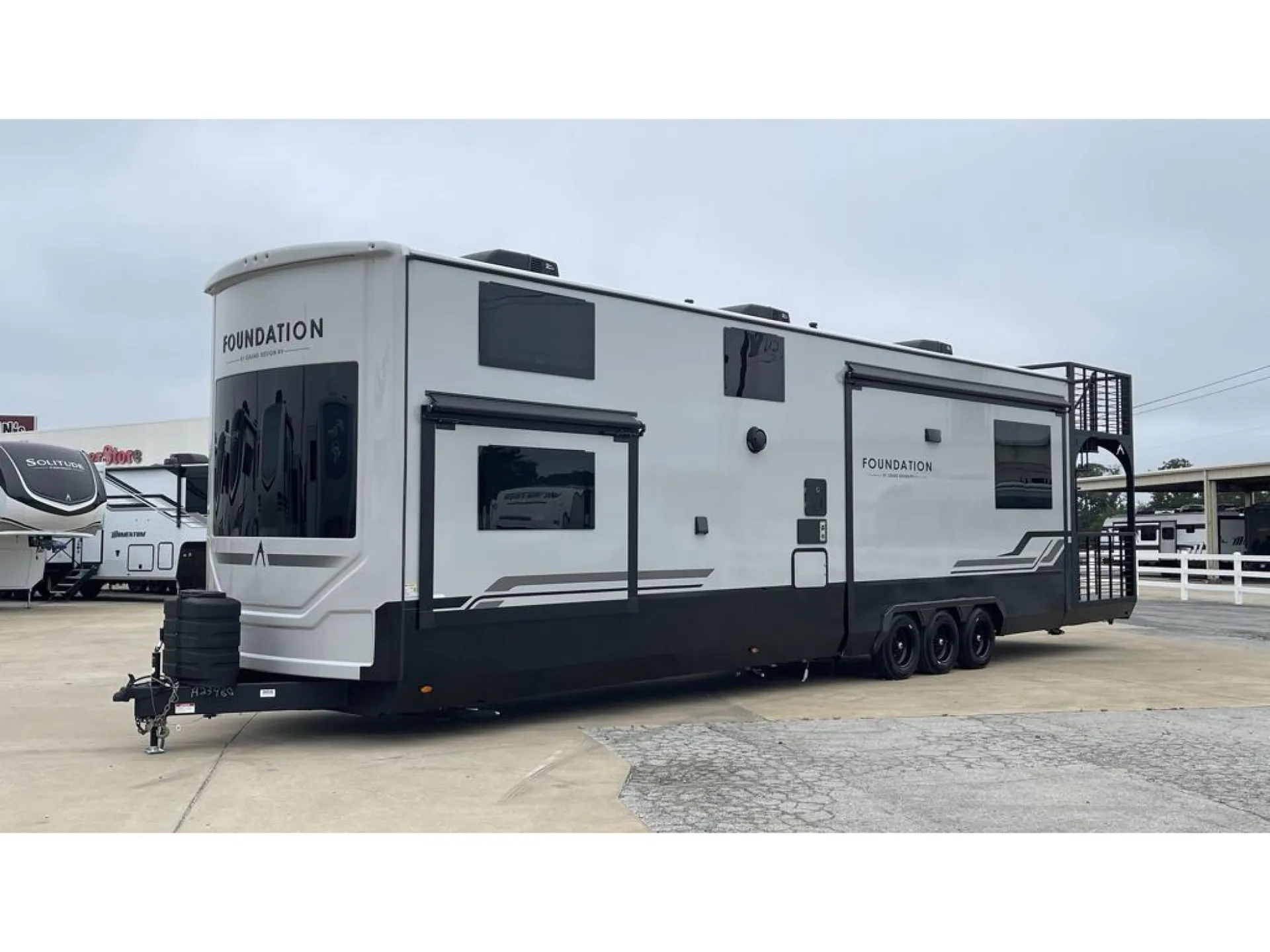 2026 Grand Design Foundation 42GD — Exterior photograph showing the opposite side of the fifth-wheel, slide-outs, windows, wheels, and rear deck structure