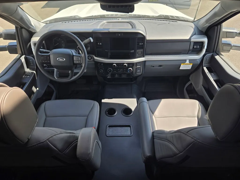 2027 Grand Design Lineage Series F 29AN5 — Class C motorhome cockpit with steering wheel, dashboard controls, central display, and two front captain’s chairs