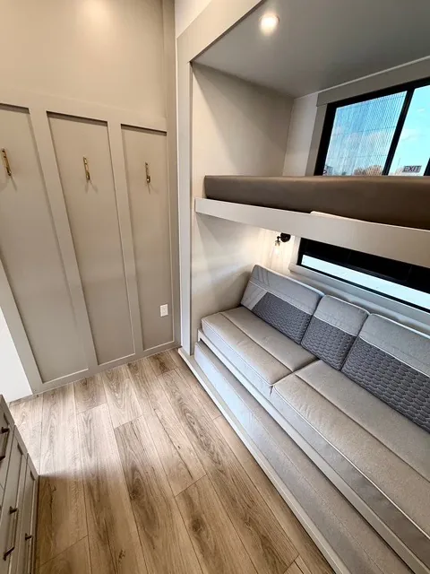2026 Brinkley Model Z 3610 — Over-cab loft mattress above a sofa in a compact fifth wheel sleeping and lounge area