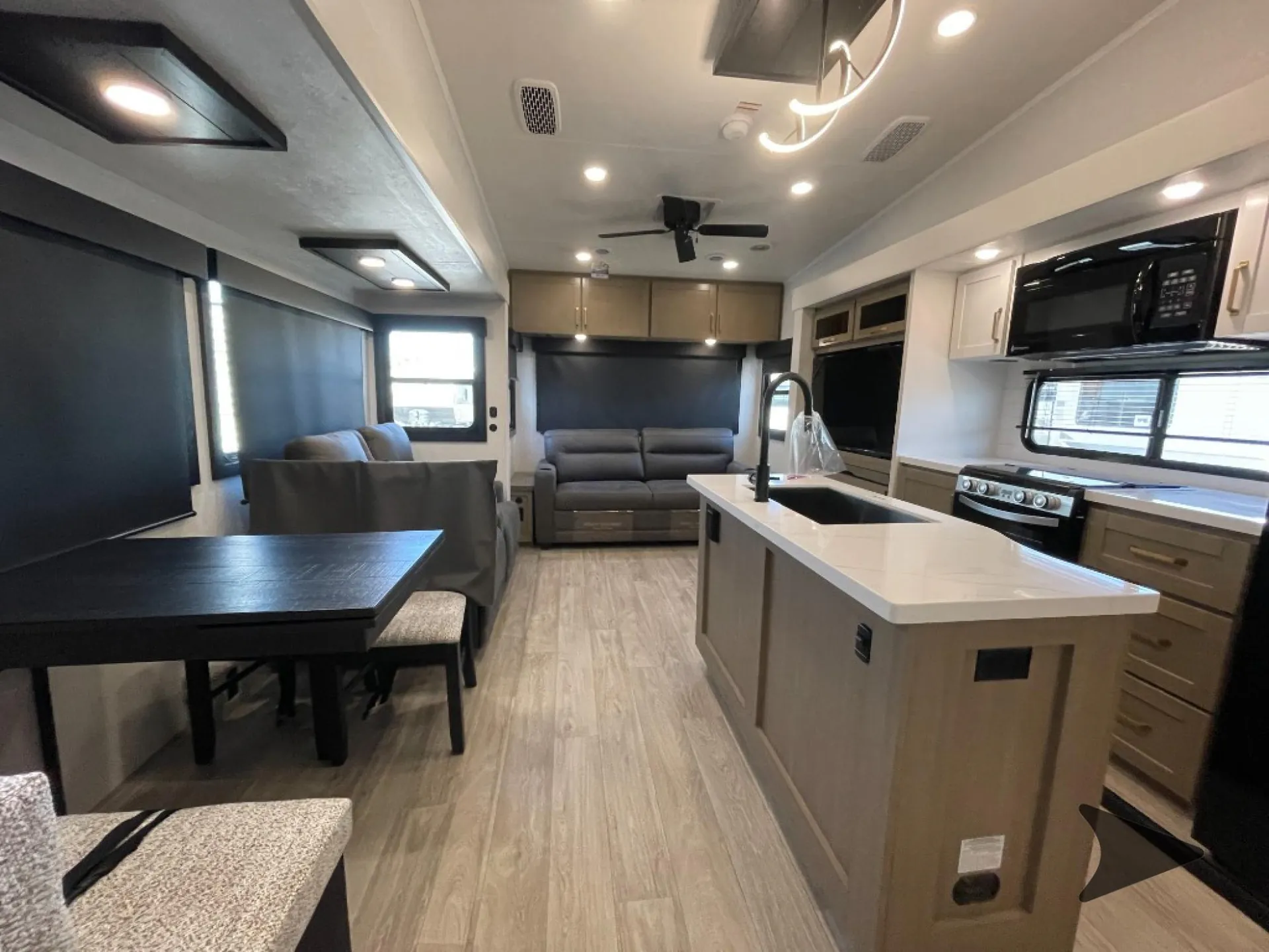 2027 Jayco Eagle 355MBQS — Fifth wheel kitchen island with sink, range, and refrigerator beside a dinette and rear sofa seating