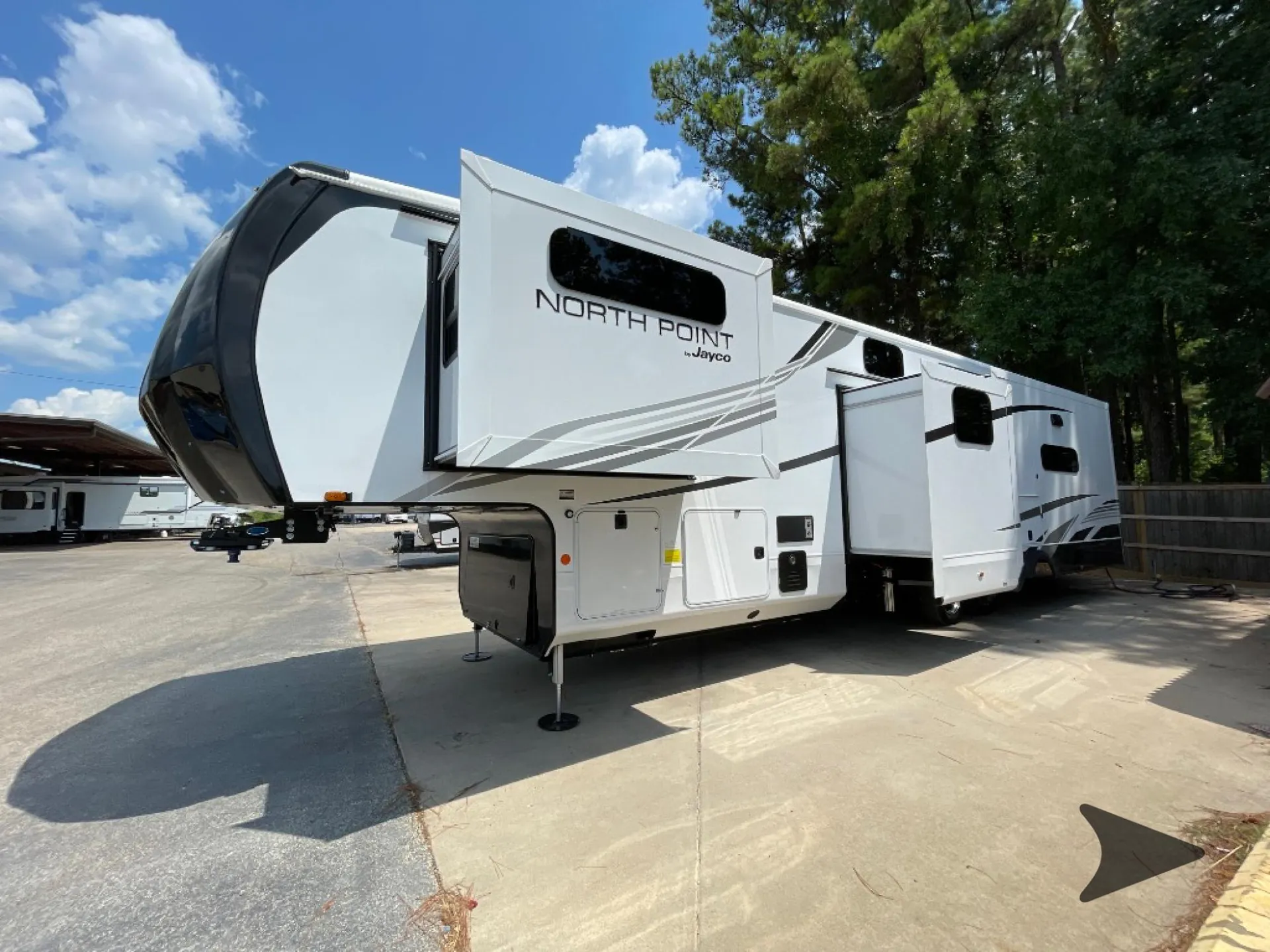 2026 Jayco North Point 377RLBH — Wide exterior photograph visibly shows the fifth-wheel shell, slide-outs, and landing gear