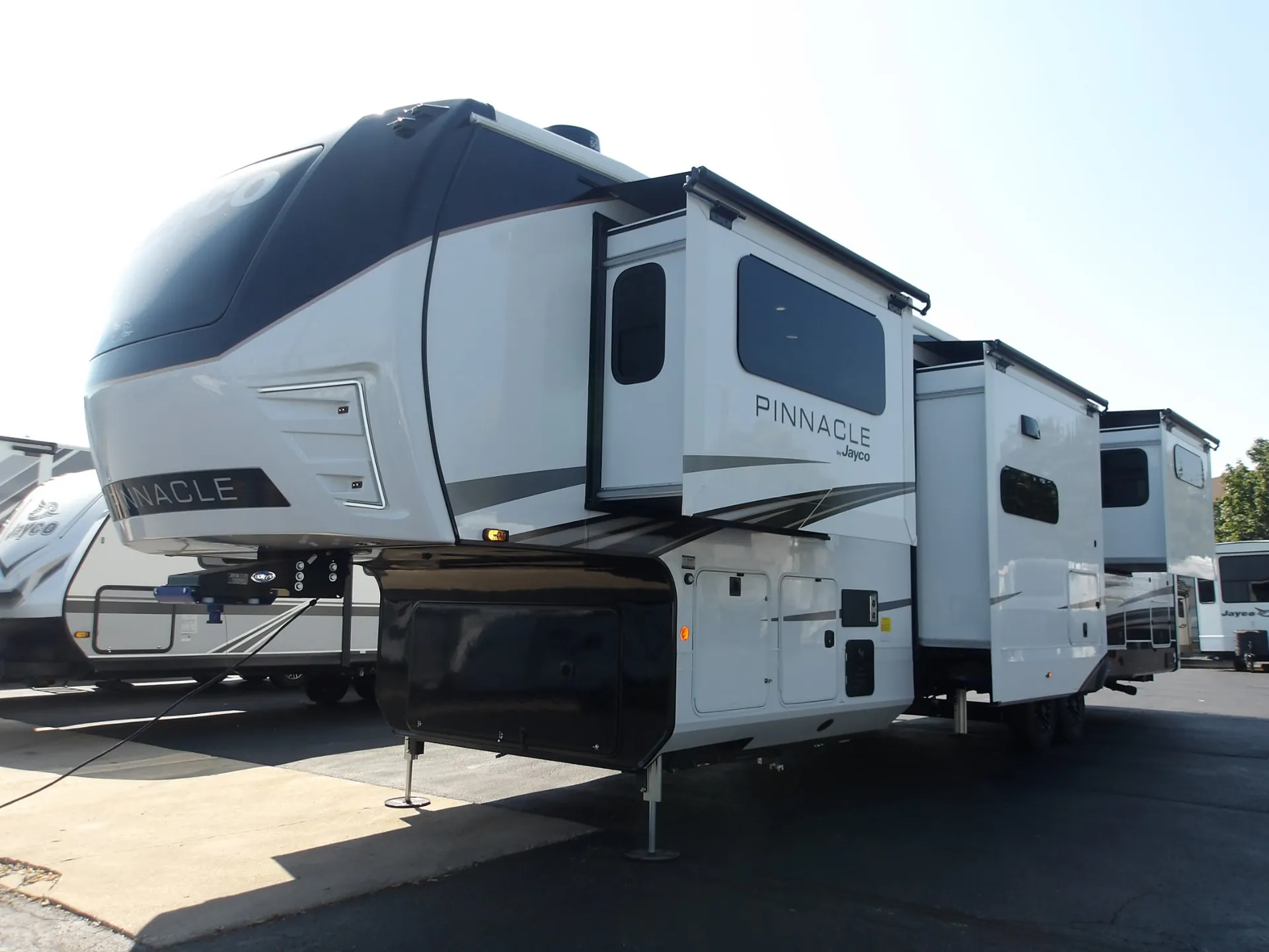 2027 Jayco Pinnacle 39FLOK — The exterior shell of a Jayco Pinnacle fifth-wheel, including hitch, slide-outs, wheels, and leveling supports