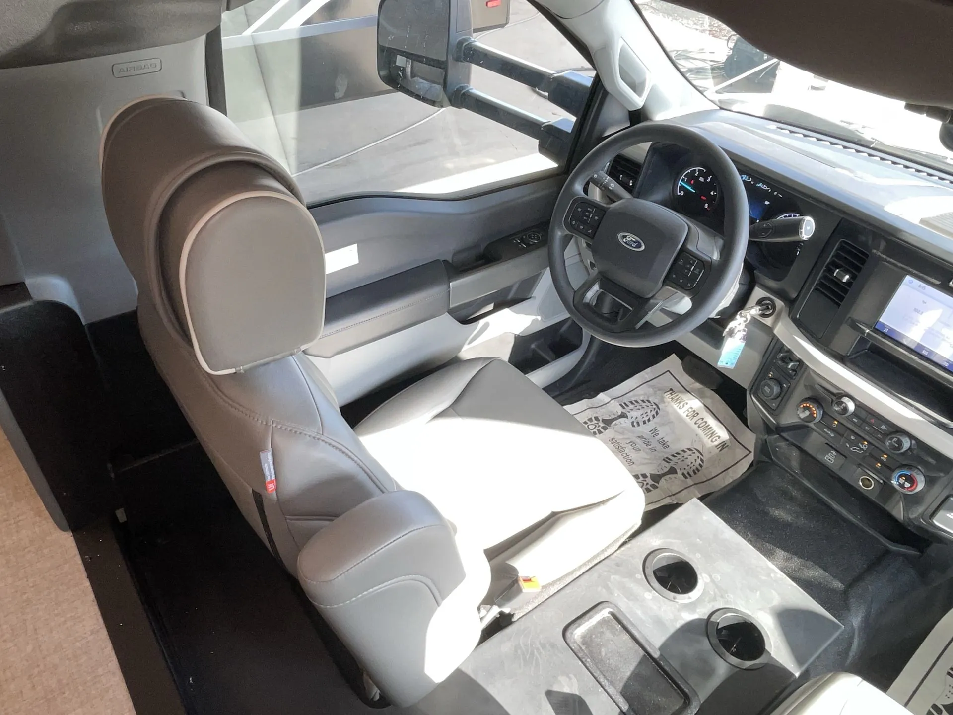 2027 Grand Design Lineage Series F 31ZW — Driver cockpit seat with steering wheel, instrument cluster, dashboard controls, and side window