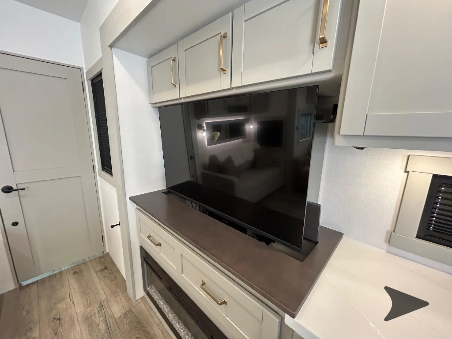 2026 Brinkley Model Z 3515 — Living-area television above a media cabinet with drawers, fireplace, and surrounding overhead cabinetry