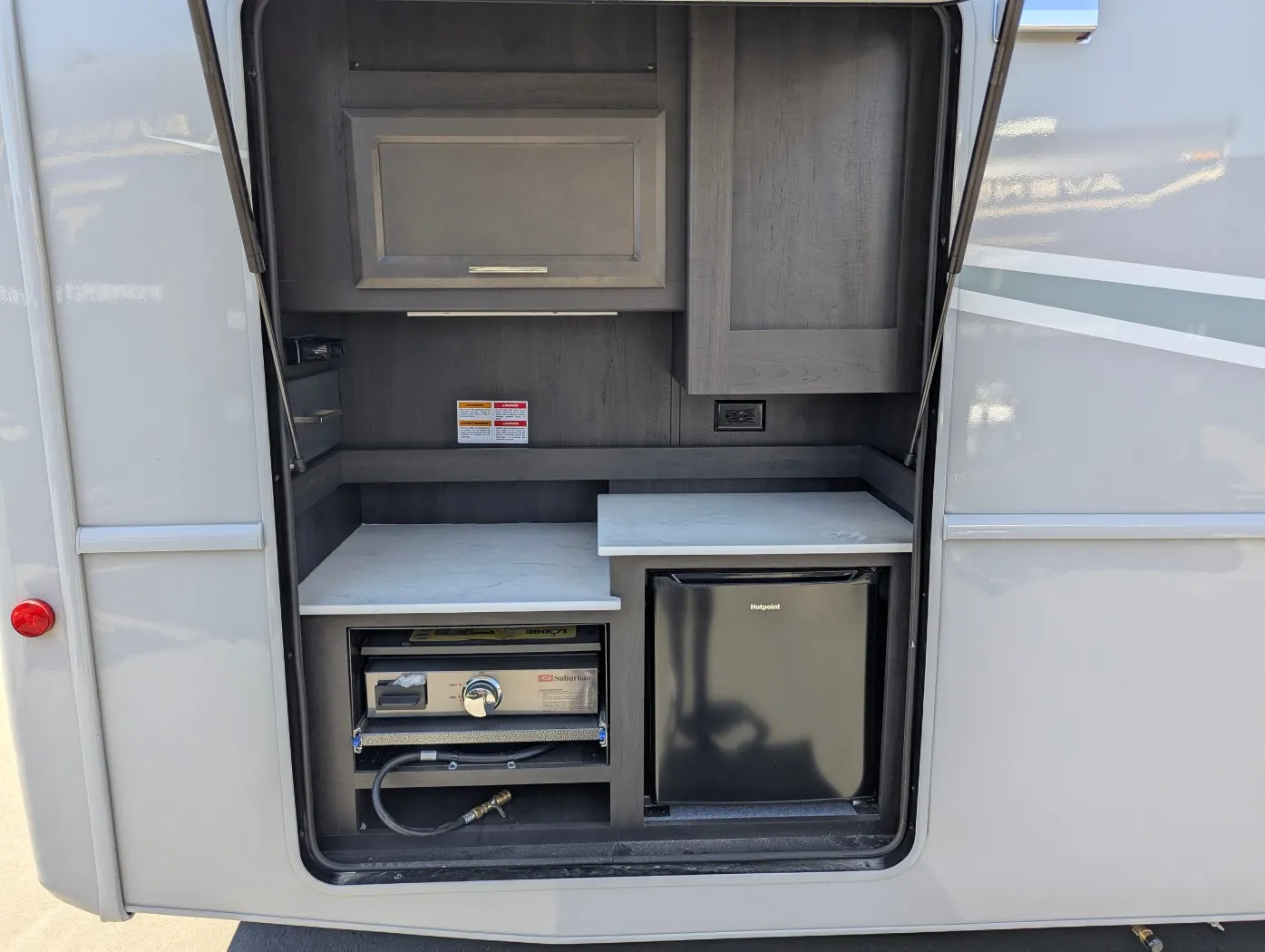 2026 Holiday Rambler Invicta 36Y — Open exterior compartment visibly contains a generator, refrigerator, wiring, and service equipment
