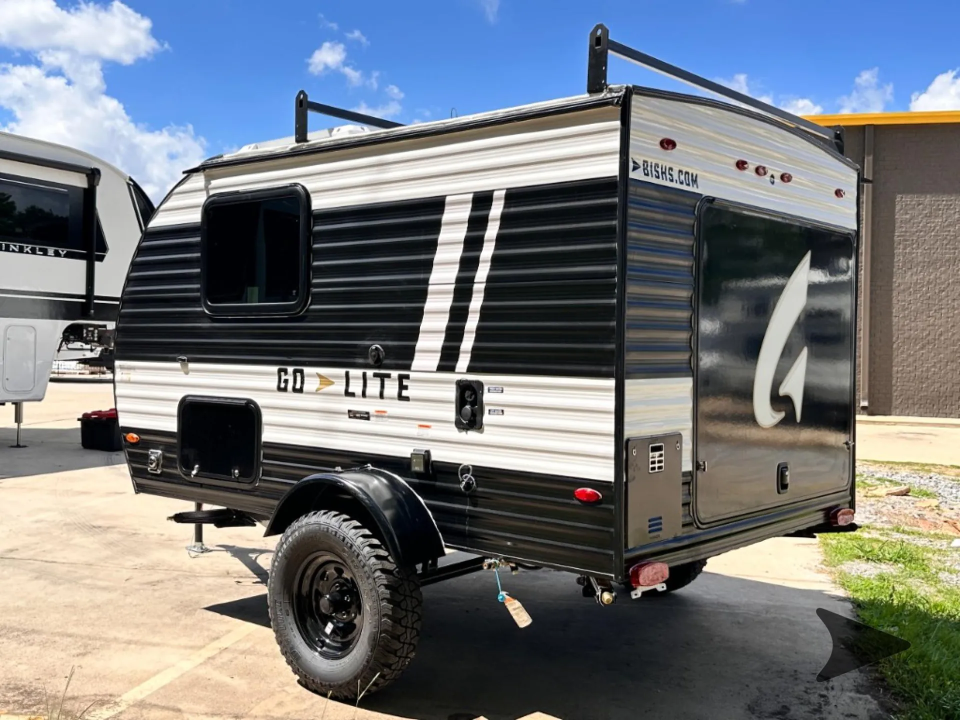 2026 Wayfinder Go Lite Solo — Clear photograph of the RV's rear and side exterior, including shell, wheel, lights, and storage doors