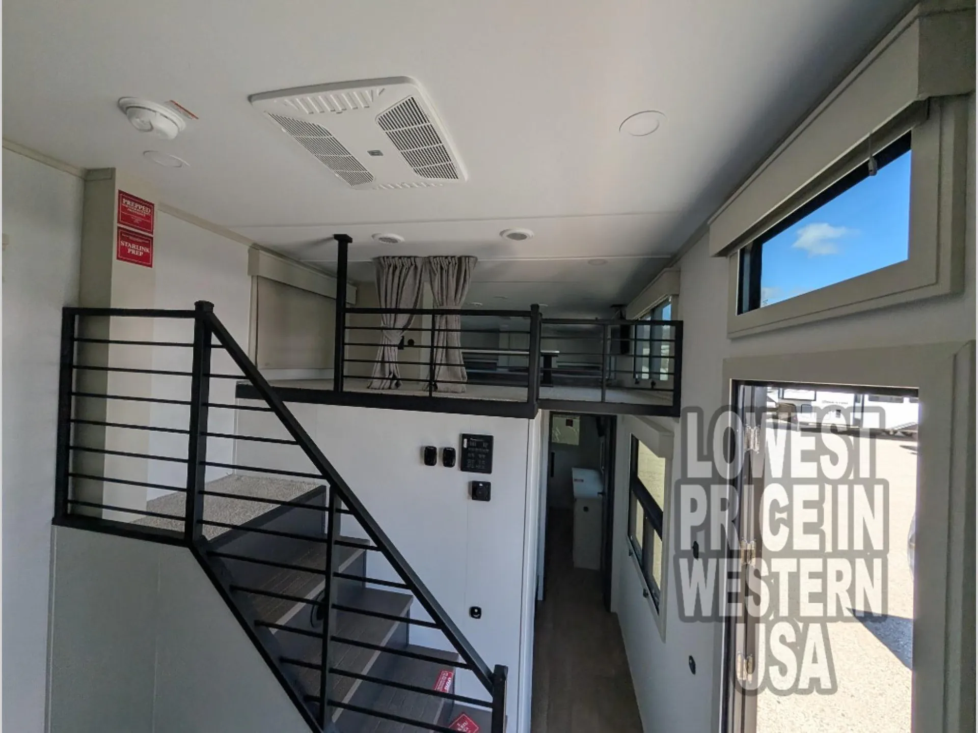 2026 Grand Design Foundation 42GD — Destination trailer staircase rises to a curtained elevated loft above the entry corridor and control panel