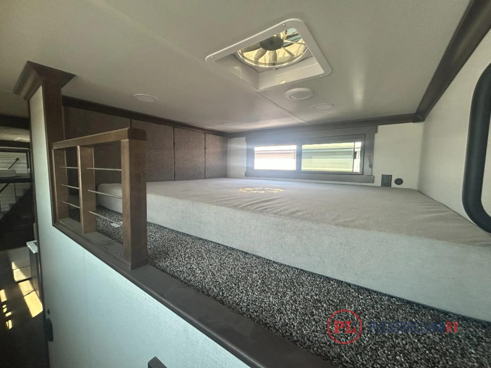 2026 Forest River Cedar Creek Cottage 41FWC — Over-cab loft sleeping platform with a mattress, side shelving, window, and ceiling vent