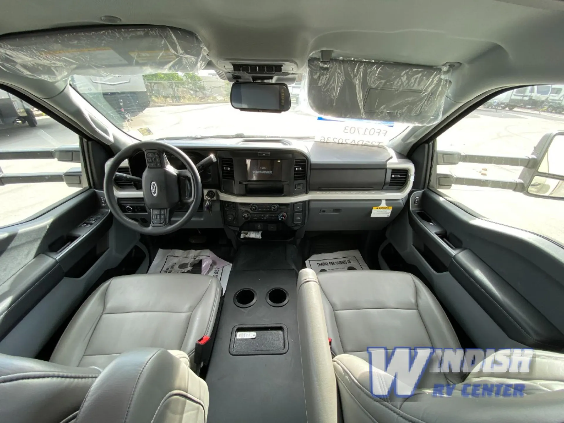 2027 Grand Design Lineage Series F 29AN5 — Class C cockpit with steering wheel, dashboard controls, center console, driver seat, passenger seat, and windshield