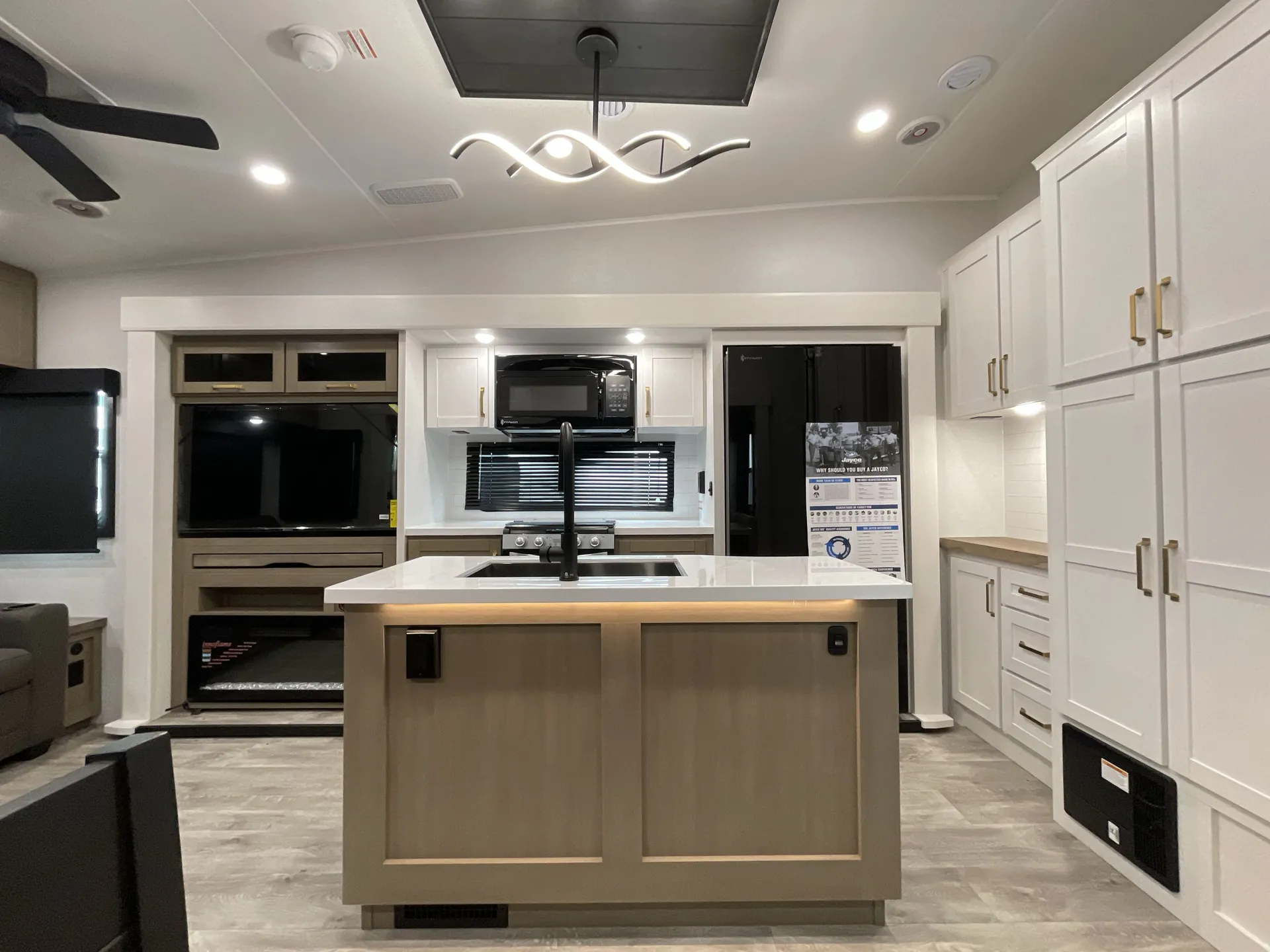 2027 Jayco Eagle 355MBQS — Kitchen island with sink, microwave, range, refrigerator, pantry cabinetry, and adjacent living room seating
