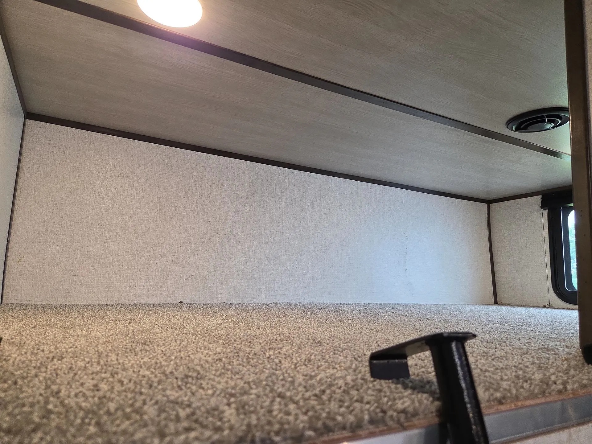 2022 Dutchmen Voltage 4225 — Elevated carpeted sleeping loft with low walls, ceiling light, vent, and access step