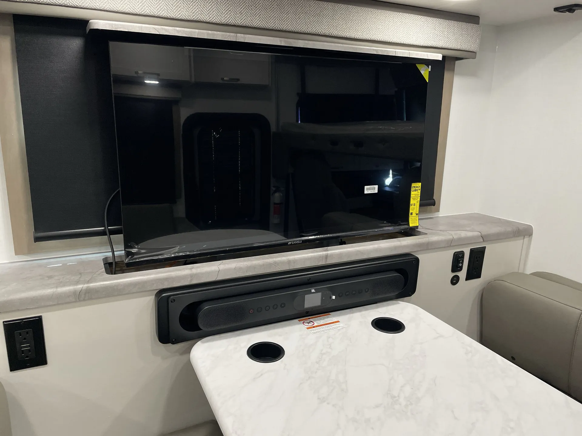 2027 Jayco Alante 29F — Class A motorhome dinette table beneath a television and soundbar with adjacent upholstered seating