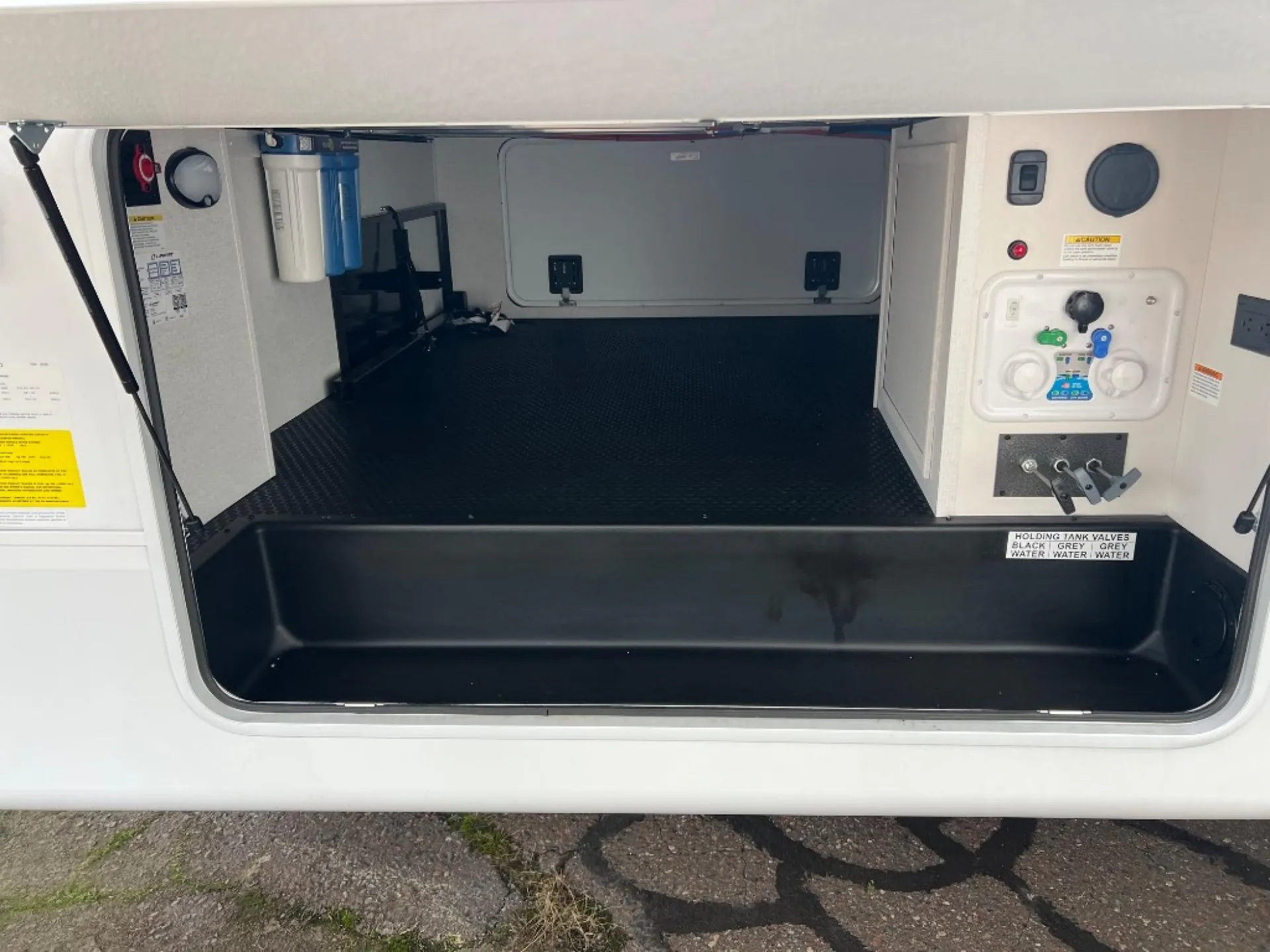 2027 Jayco Eagle 355MBQS — Open exterior cargo compartment is visibly shown, with storage space and installed utility equipment