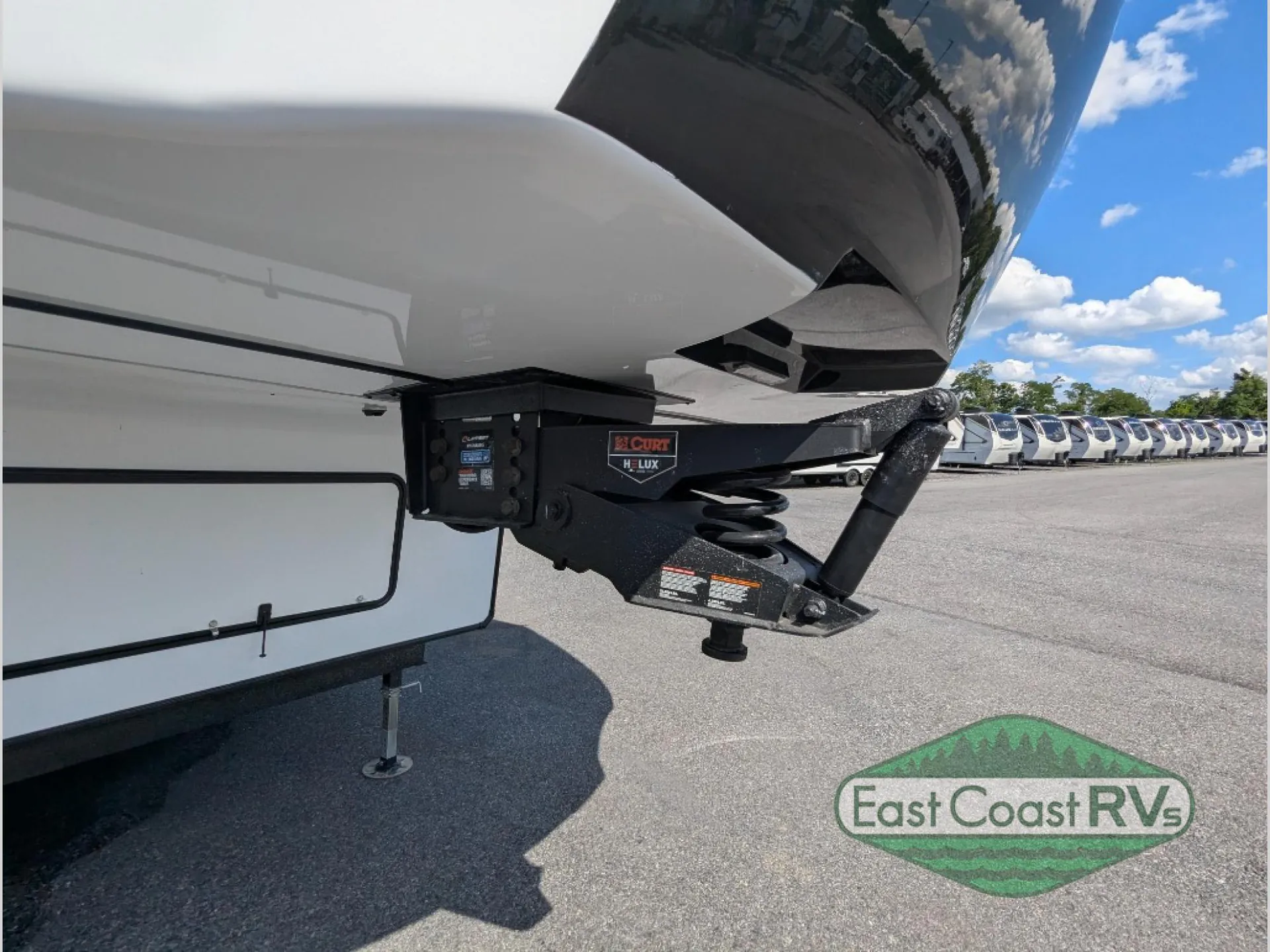 2027 Forest River Sanibel 40BUNK — Close exterior photograph visibly shows the fifth-wheel hitch, suspension components, and mechanical hardware
