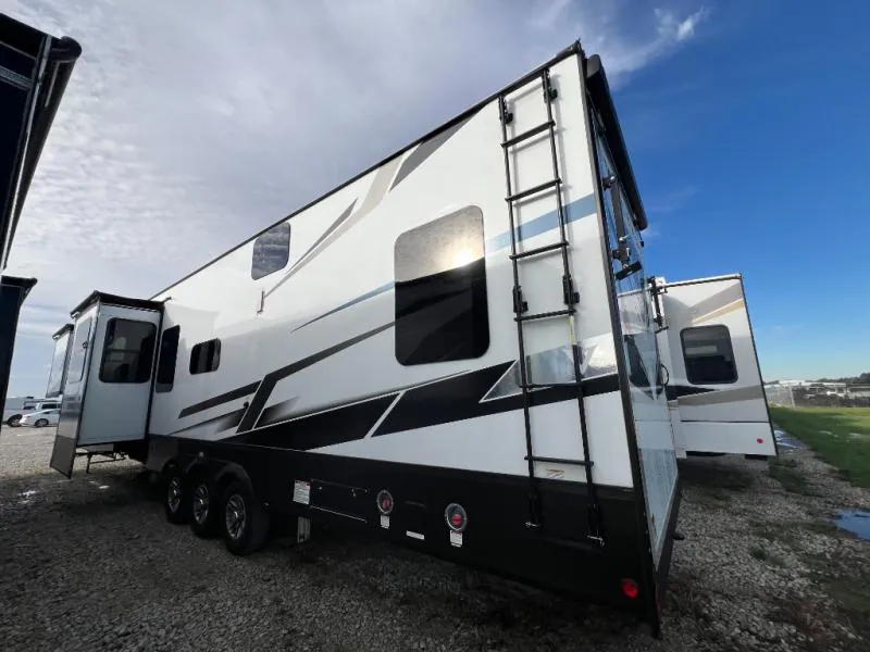 2023 Dutchmen Voltage 4225 — Rear-side exterior photograph visibly shows the RV body, rear ladder, windows, wheels, and slide-out