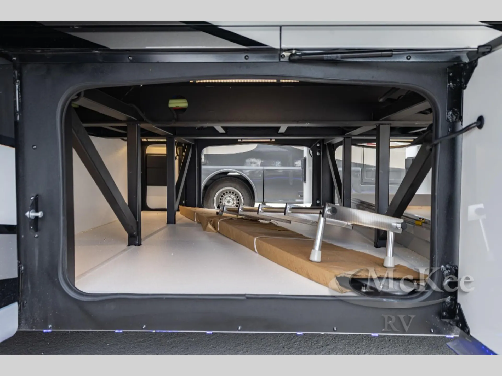 2027 Fleetwood Discovery LXE 40M — Open exterior pass-through/cargo bay with structural supports and stored equipment visible