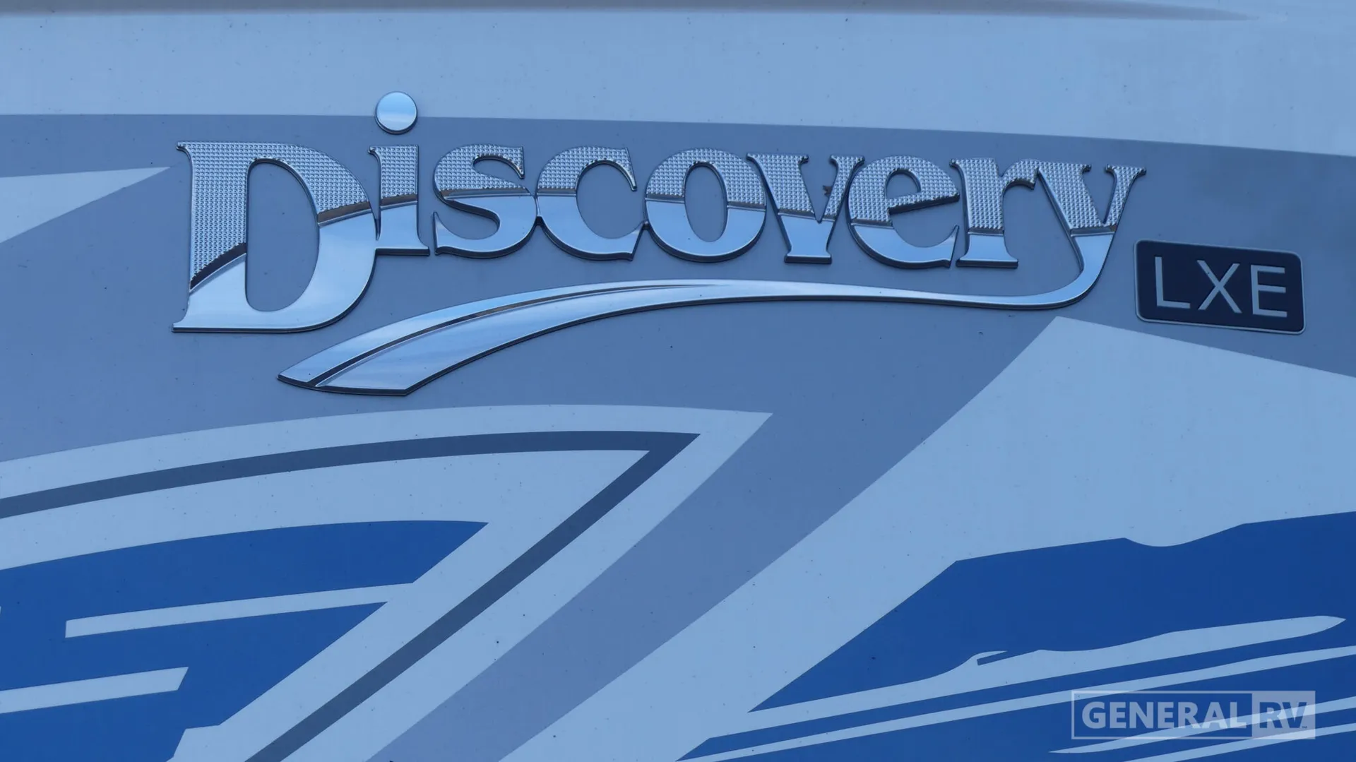 2026 Fleetwood Discovery LXE 40G — Visible Discovery LXE branding is mounted on the RV's exterior side panel