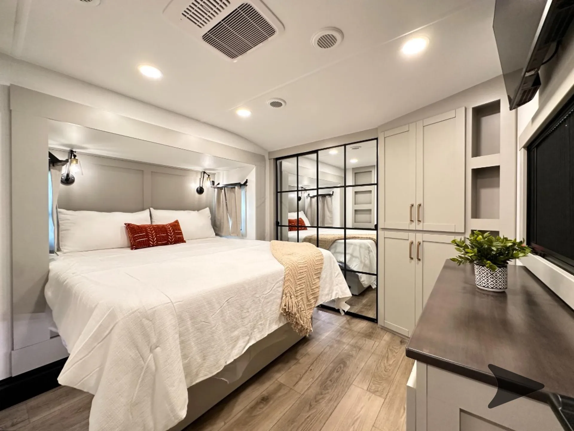 2026 Brinkley Model Z 3610 — Fifth wheel bedroom with a made bed, mirrored wardrobe, dresser, and overhead storage