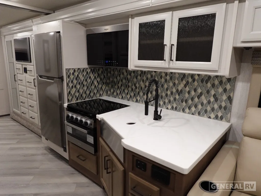 2026 Holiday Rambler Invicta 36Y — Motorhome kitchen with stainless refrigerator, microwave, range, sink, island counter, and patterned backsplash