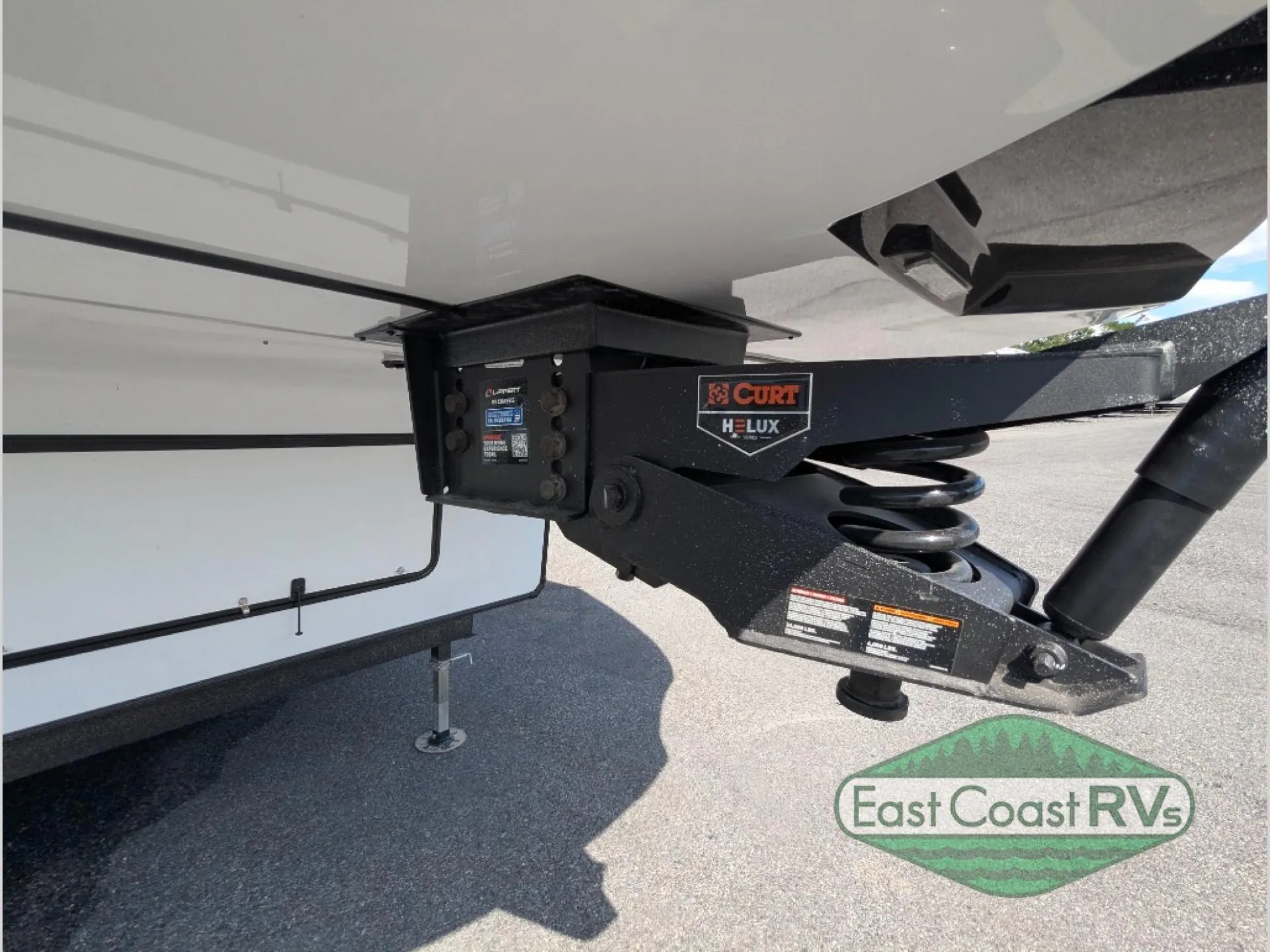 2027 Forest River Sanibel 40BUNK — Close exterior photograph visibly shows the fifth-wheel hitch assembly and associated mechanical hardware