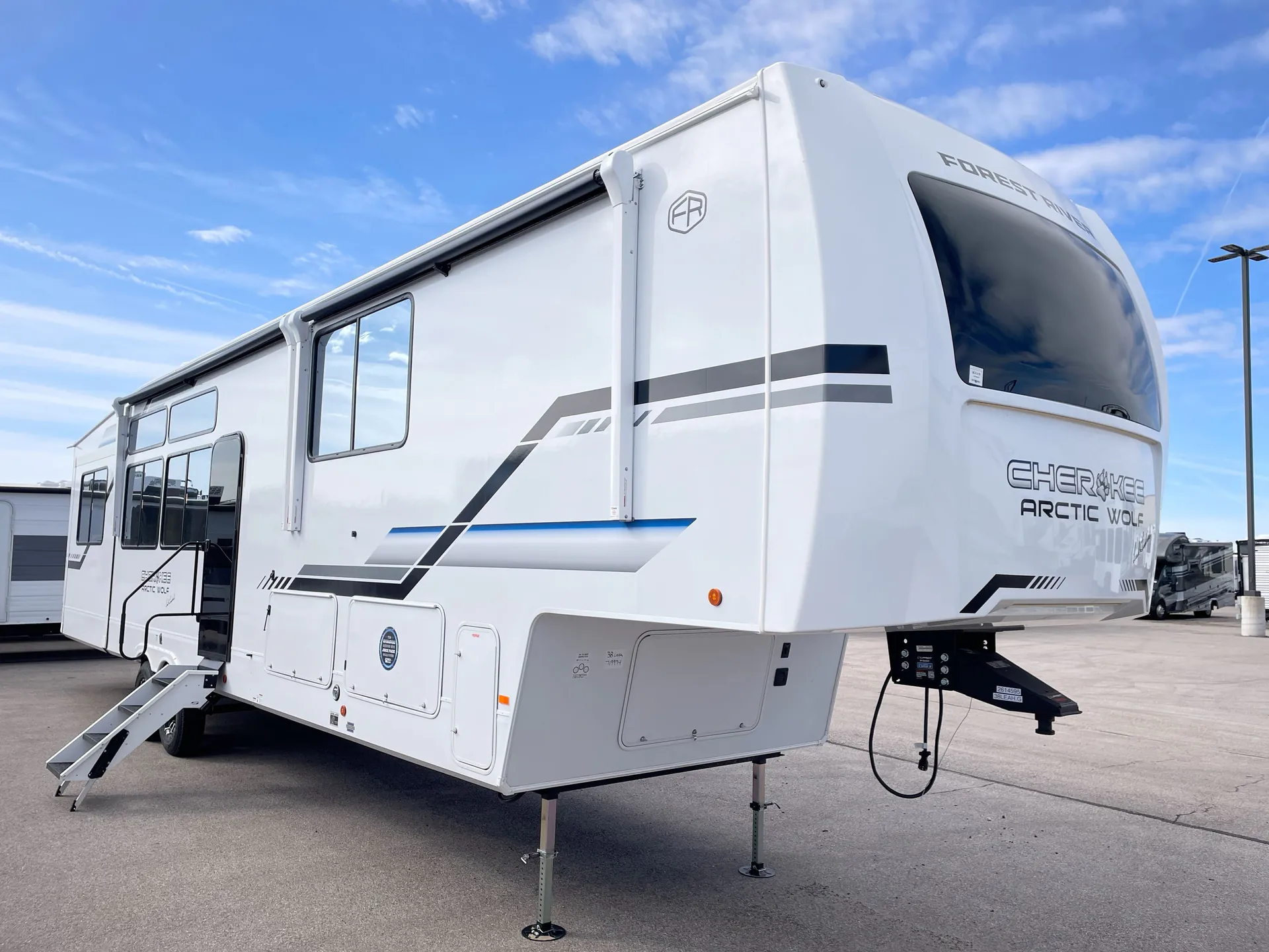 2026 Forest River Arctic Wolf 38LEAH.G — The outside front and side of a fifth-wheel RV, including hitch, shell, windows, and exterior compartments