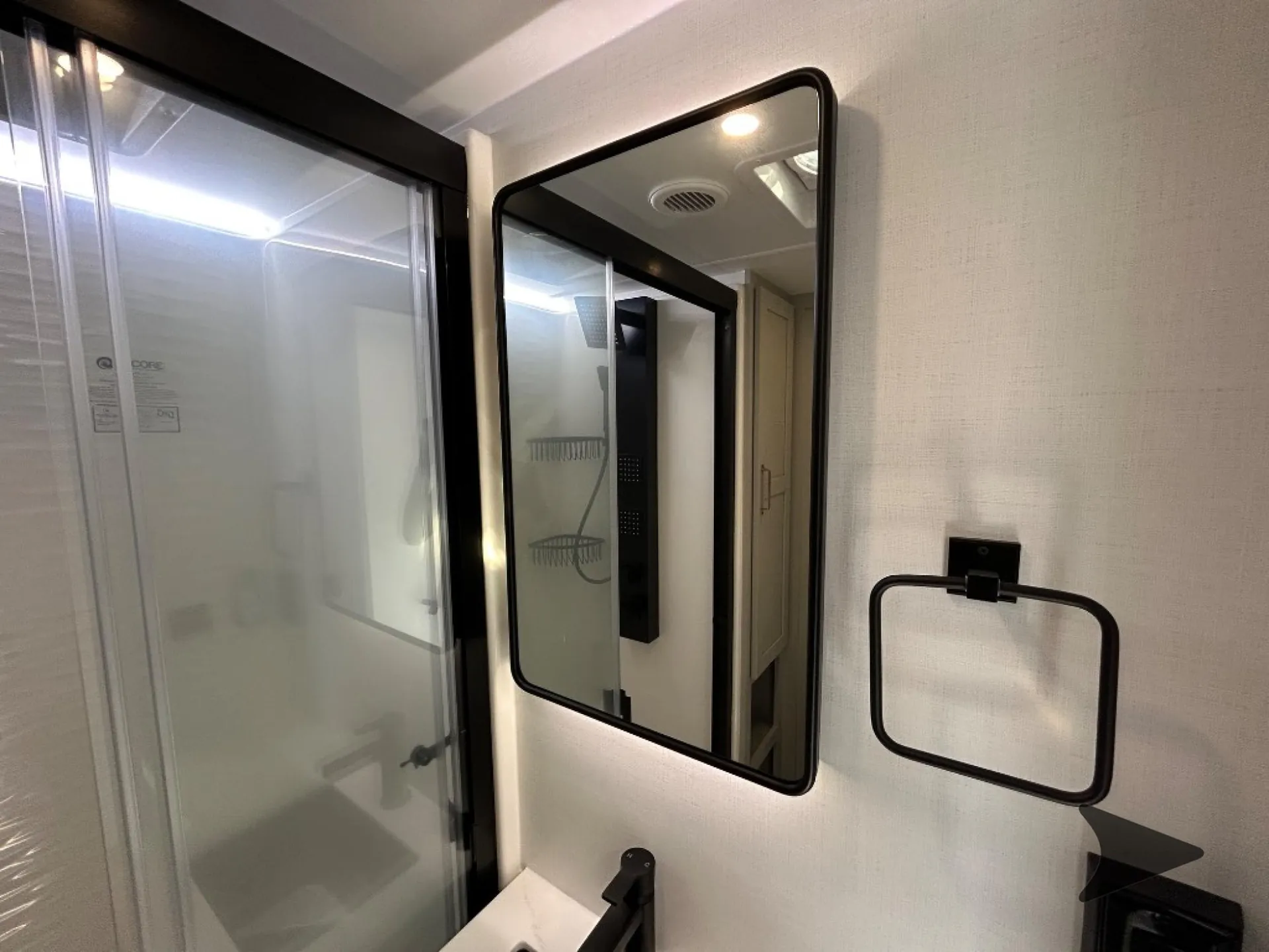 2026 Brinkley Model Z 3515 — Bathroom vanity wall with large mirror, towel holder, shower enclosure, and reflected shower fixtures