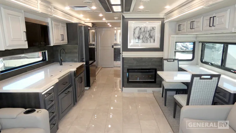 2027 Fleetwood Discovery LXE 40M — Class A motorhome kitchen, dinette, and lounge arranged in one open interior with island counter, fireplace, and seating