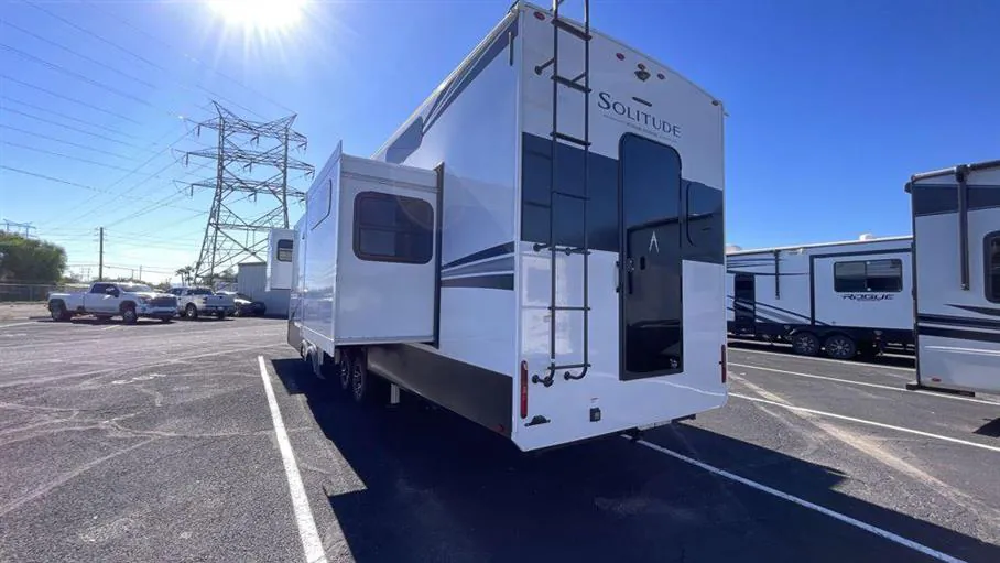 2026 Grand Design Solitude 391DL — Rear-side photograph visibly shows the RV shell, rear ladder, side wall, and exterior slide-out