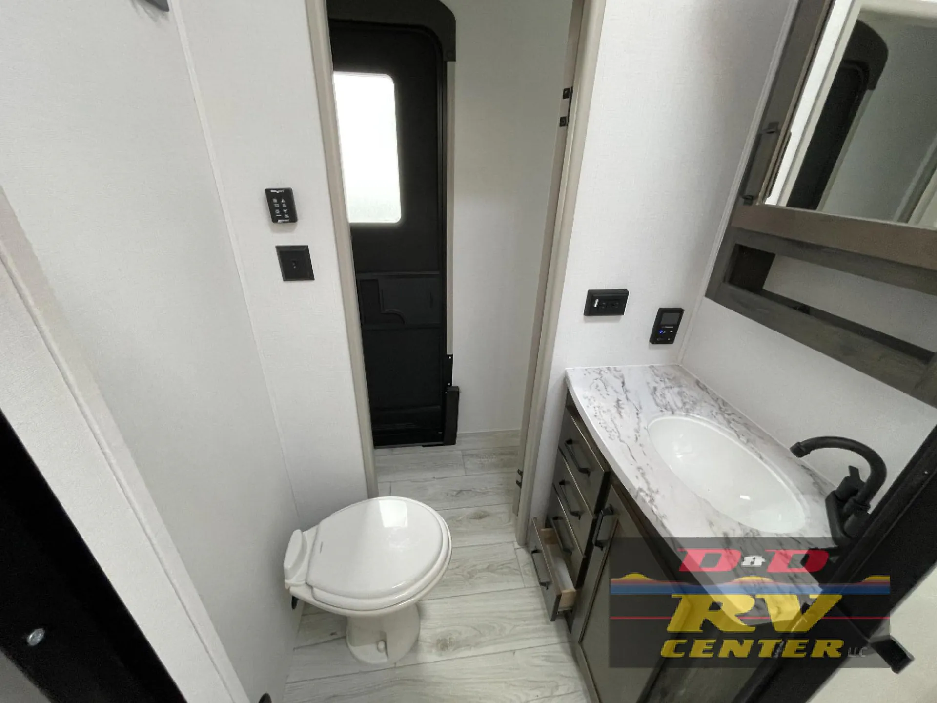 2026 Keystone Montana High Country 377FL — Fifth wheel bathroom with toilet, marble-look vanity countertop, sink, faucet, drawers, and entry door