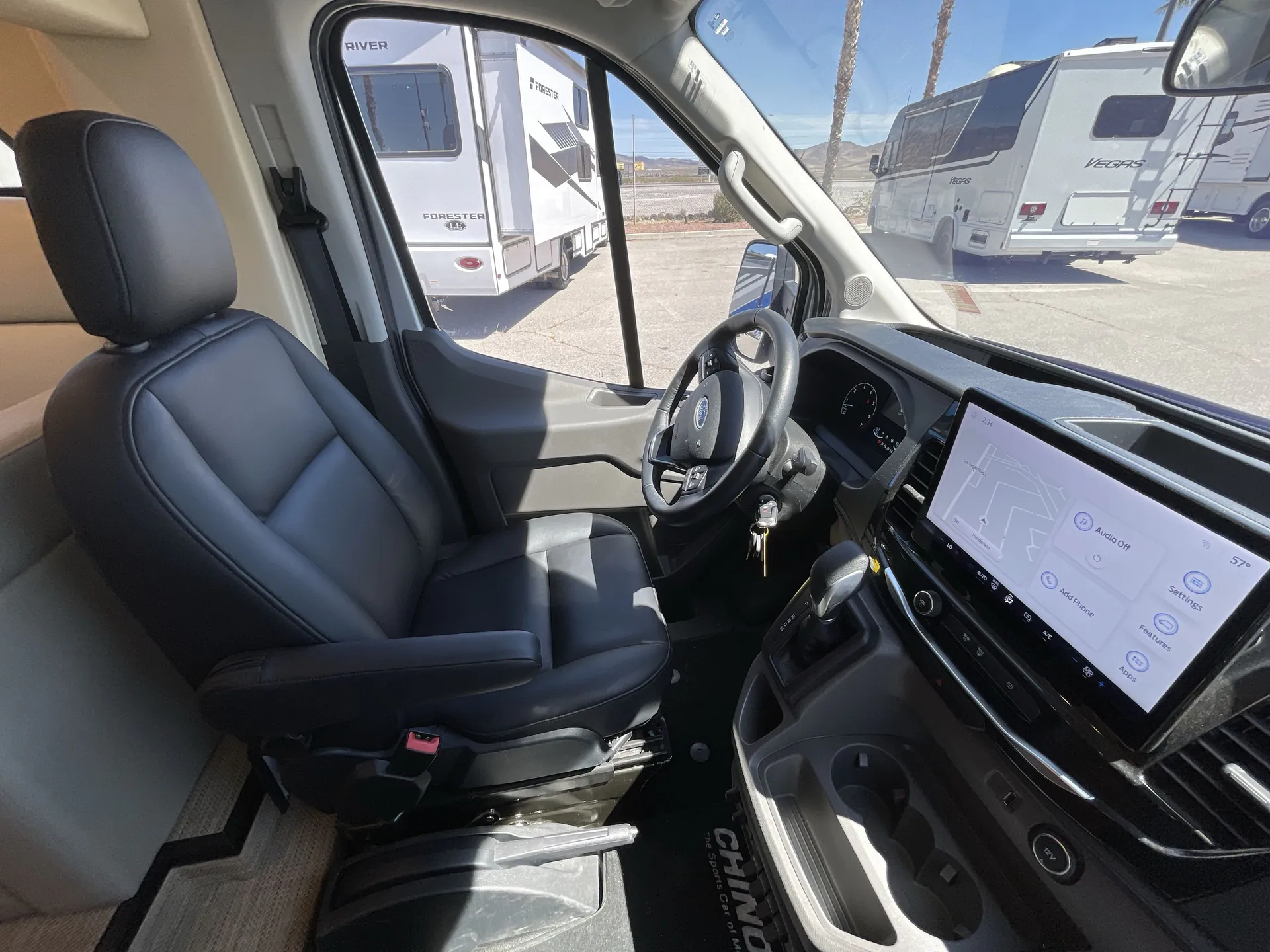 2024 Chinook RV Maverick SS — Driver cockpit with steering wheel, instrument panel, touchscreen, gear selector, and driver seat