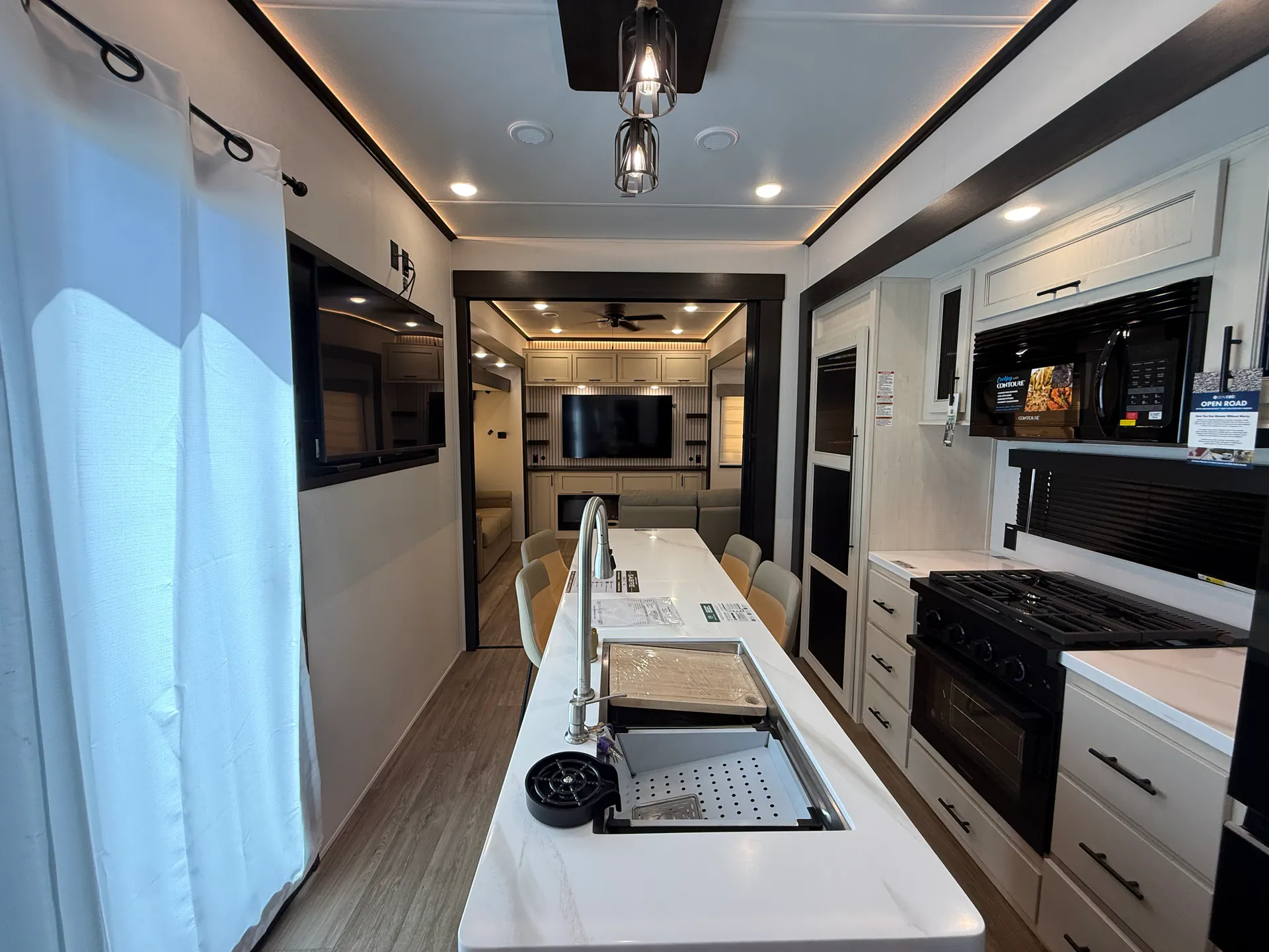 2027 Forest River Sabre 38RVHUNTER — Fifth wheel kitchen island with sink and range facing a dining table and entertainment seating area